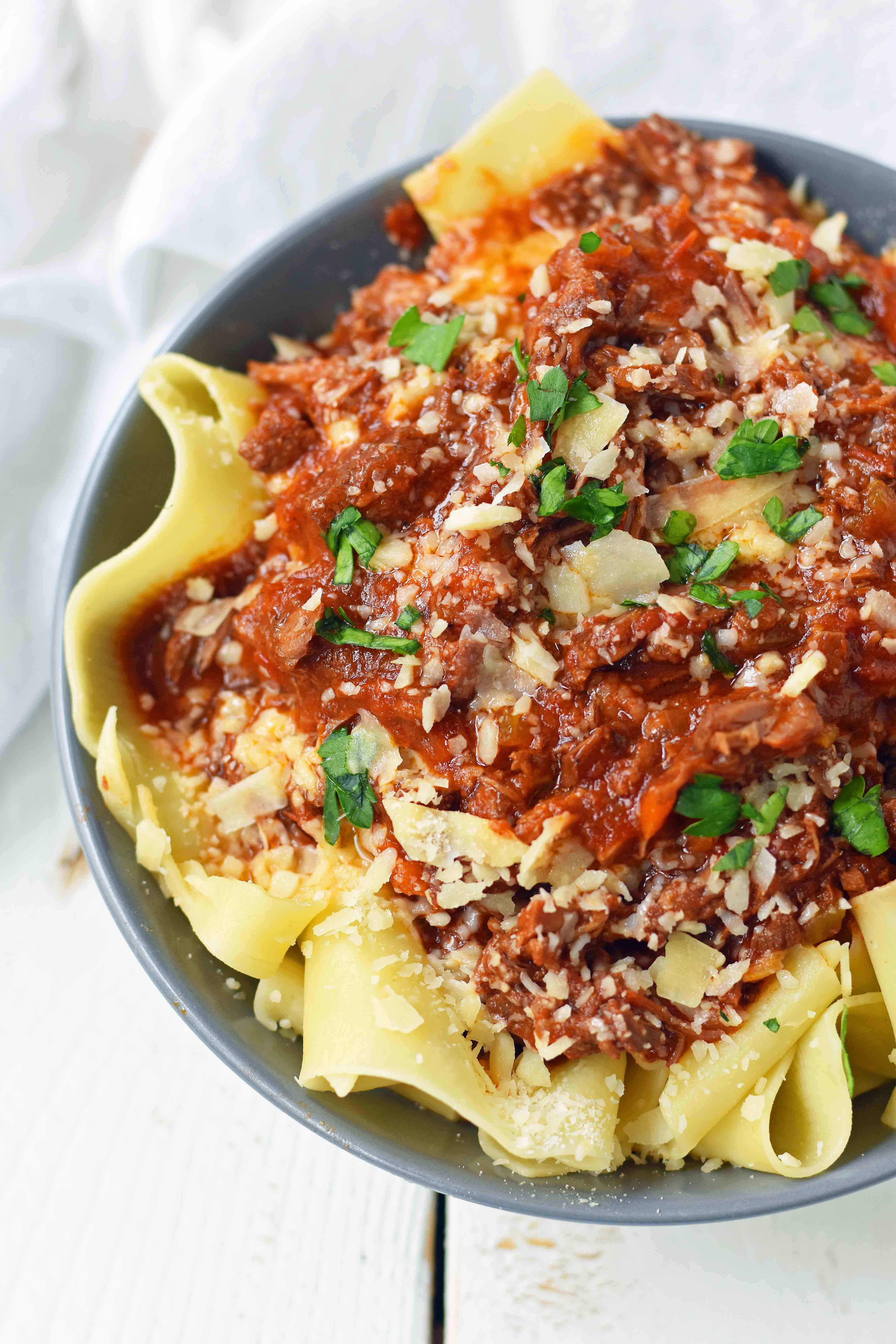 This braised shredded beef ragu with pappardelle pasta can be made in a slow cooker or instant pot pressure cooker. It makes the most tender, flavorful beef in a rich, velvety sauce. It is the ultimate comfort meal in a bowl! This Beef Ragu can be put on top of spiralized vegetables, mashed potatoes, or polenta for a gluten-free dinner. www.modernhoney.com 