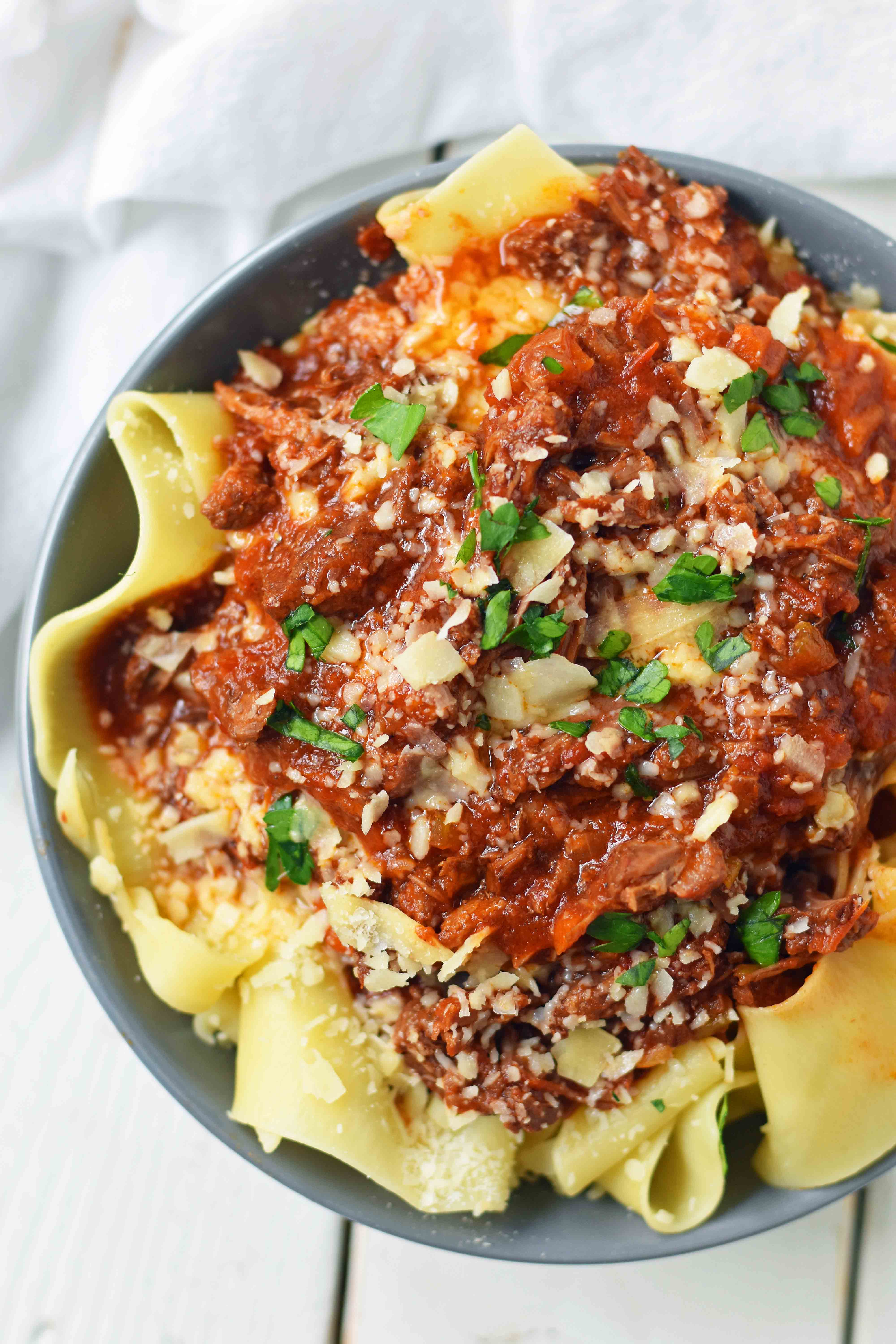 This braised shredded beef ragu with pappardelle pasta can be made in a slow cooker or instant pot pressure cooker. It makes the most tender, flavorful beef in a rich, velvety sauce. It is the ultimate comfort meal in a bowl! This Beef Ragu can be put on top of spiralized vegetables, mashed potatoes, or polenta for a gluten-free dinner. www.modernhoney.com 