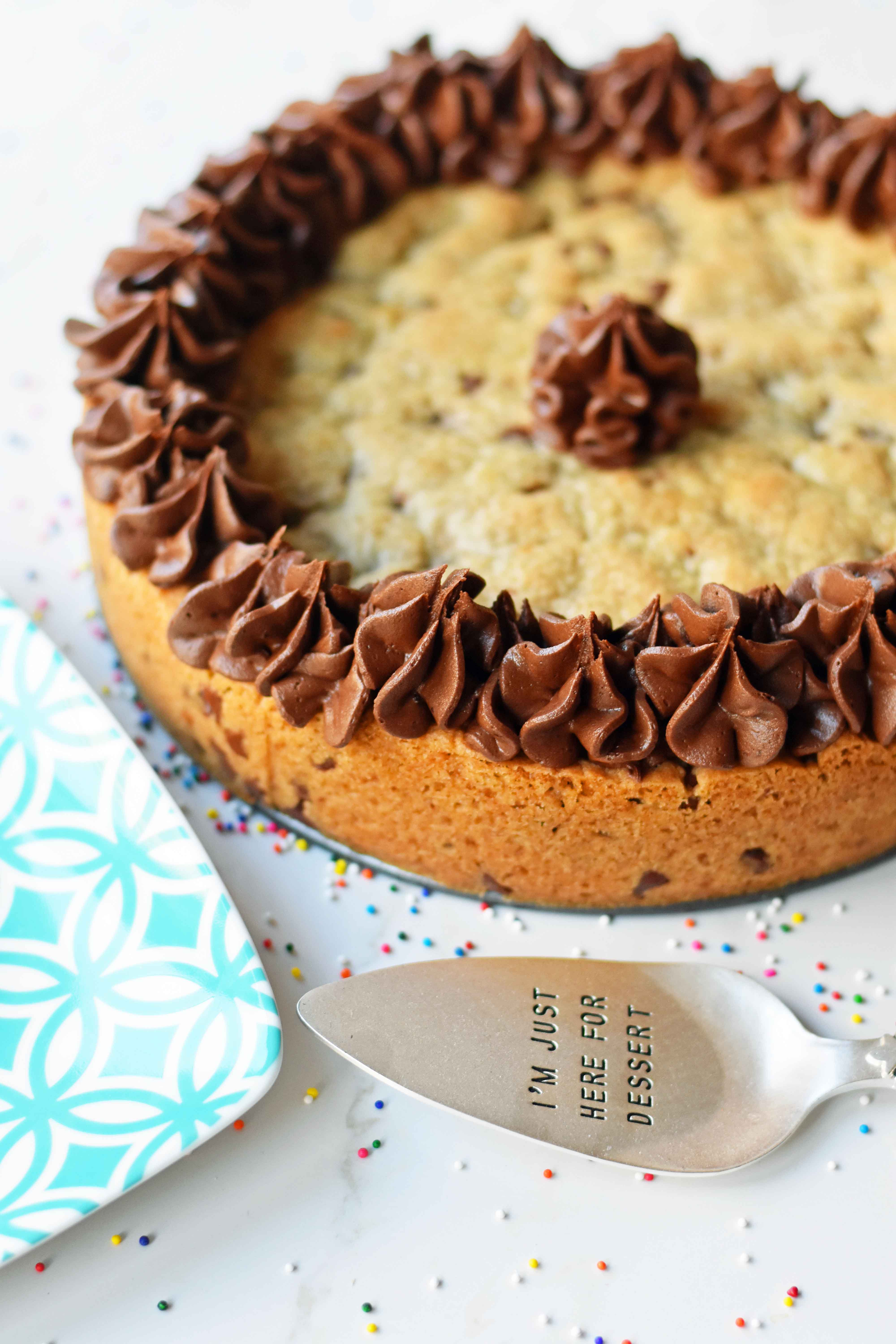 Chocolate Chip Cookie Cake. The BEST Homemade Cookie Cake. This Gigantic Frosted Chocolate Chip Cookie is perfect for birthdays or celebrations. A large decorated chocolate chip cookie recipe. www.modernhoney.com #cookie #cookies #largecookie #giganticcookie #frostedcookie #happybirthdaycookie #birthdaycookie #birthdaycookiecake #birthdaydesserts www.modernhoney.com