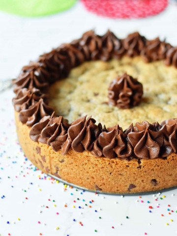 Chocolate Chip Cookie Cake. The BEST Homemade Cookie Cake. This Gigantic Frosted Chocolate Chip Cookie is perfect for birthdays or celebrations. A large decorated chocolate chip cookie recipe. www.modernhoney.com #cookie #cookies #largecookie #giganticcookie #frostedcookie #happybirthdaycookie #birthdaycookie #birthdaycookiecake #birthdaydesserts www.modernhoney.com