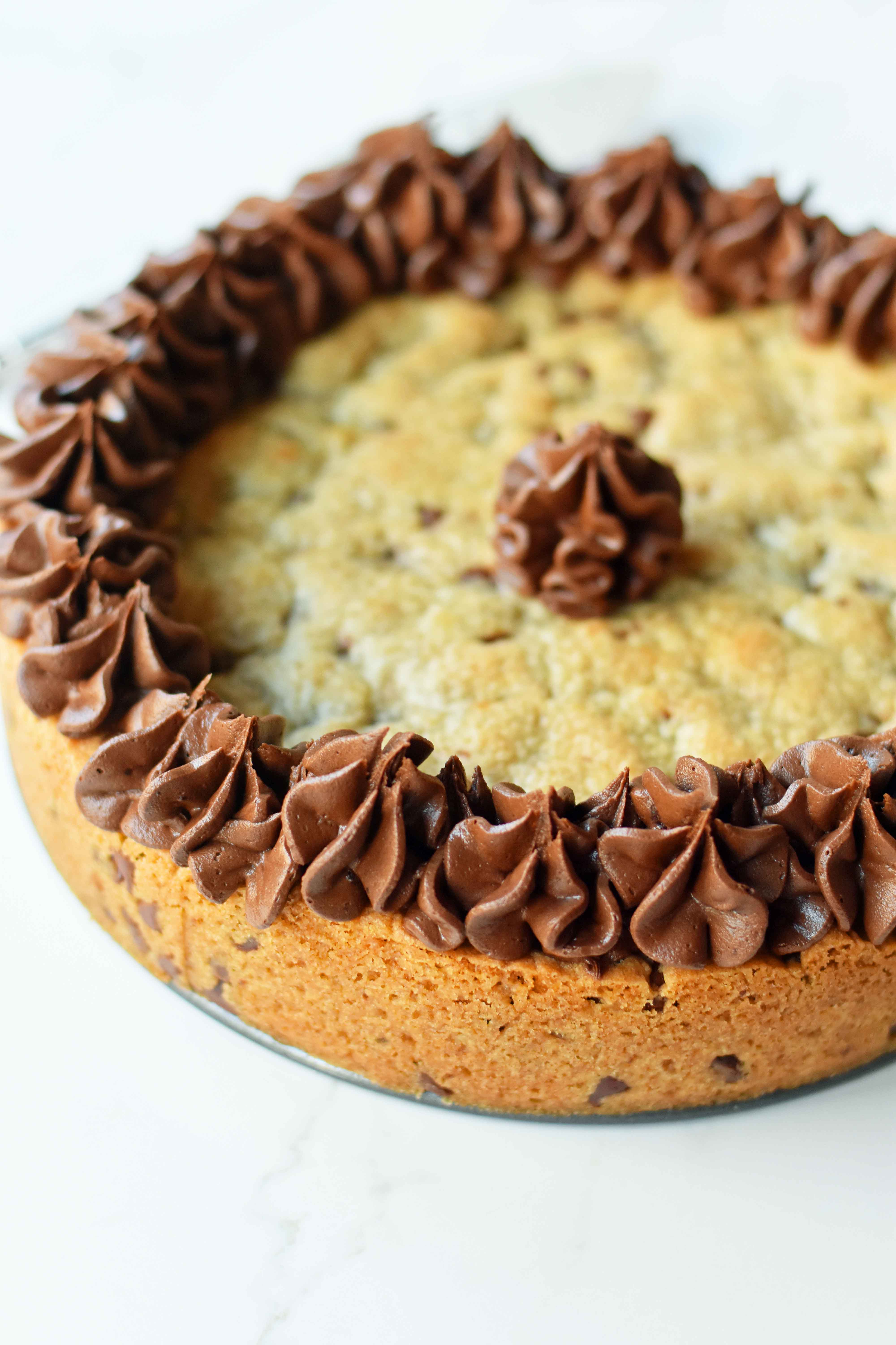 Chocolate Chip Cookie Cake. The BEST Homemade Cookie Cake. This Gigantic Frosted Chocolate Chip Cookie is perfect for birthdays or celebrations. A large decorated chocolate chip cookie recipe. www.modernhoney.com #cookie #cookies #largecookie #giganticcookie #frostedcookie #happybirthdaycookie #birthdaycookie #birthdaycookiecake #birthdaydesserts www.modernhoney.com