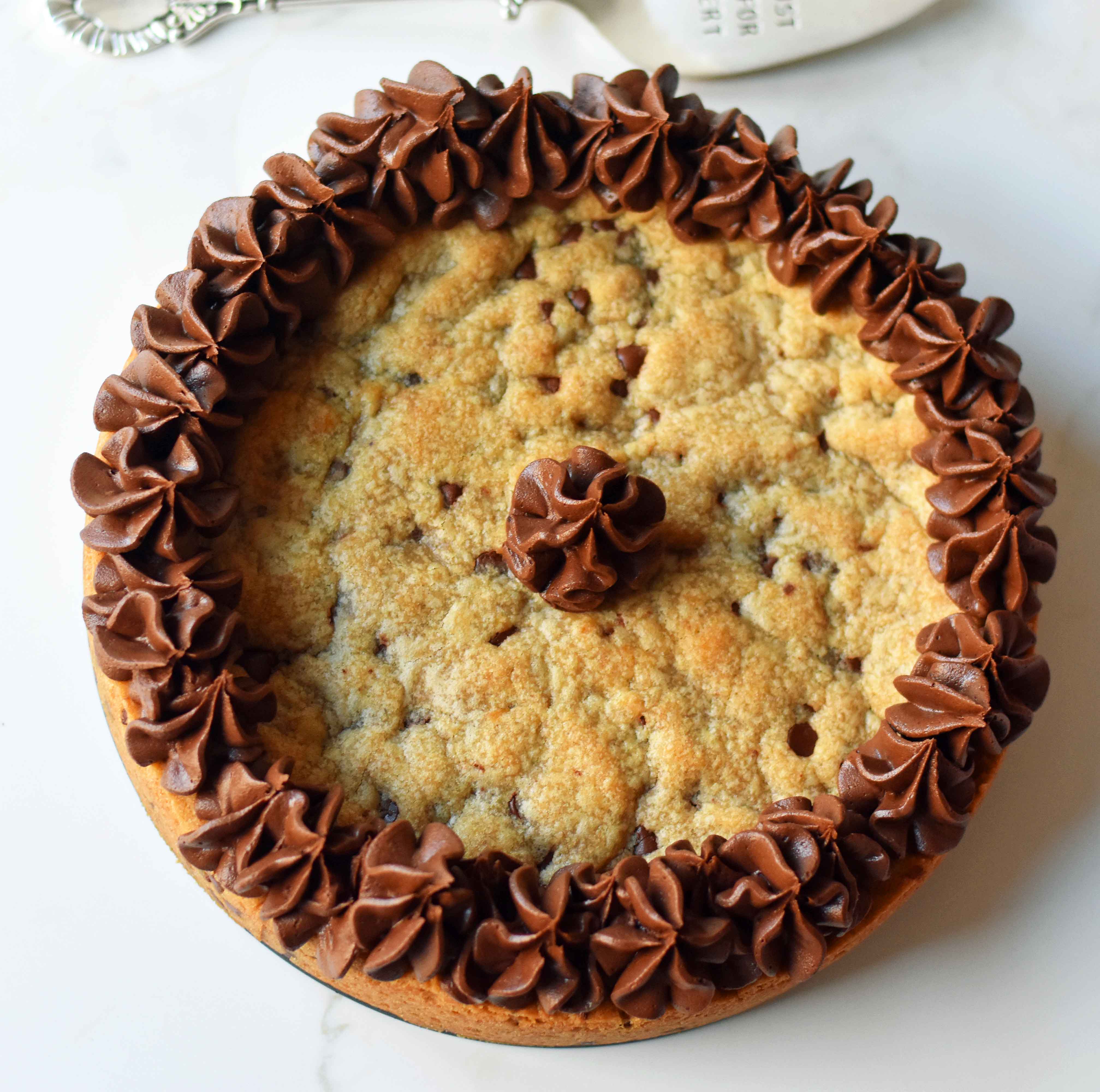 Chocolate Chip Cookie Cake. The BEST Homemade Cookie Cake. This Gigantic Frosted Chocolate Chip Cookie is perfect for birthdays or celebrations. A large decorated chocolate chip cookie recipe. www.modernhoney.com #cookie #cookies #largecookie #giganticcookie #frostedcookie #happybirthdaycookie #birthdaycookie #birthdaycookiecake #birthdaydesserts www.modernhoney.com