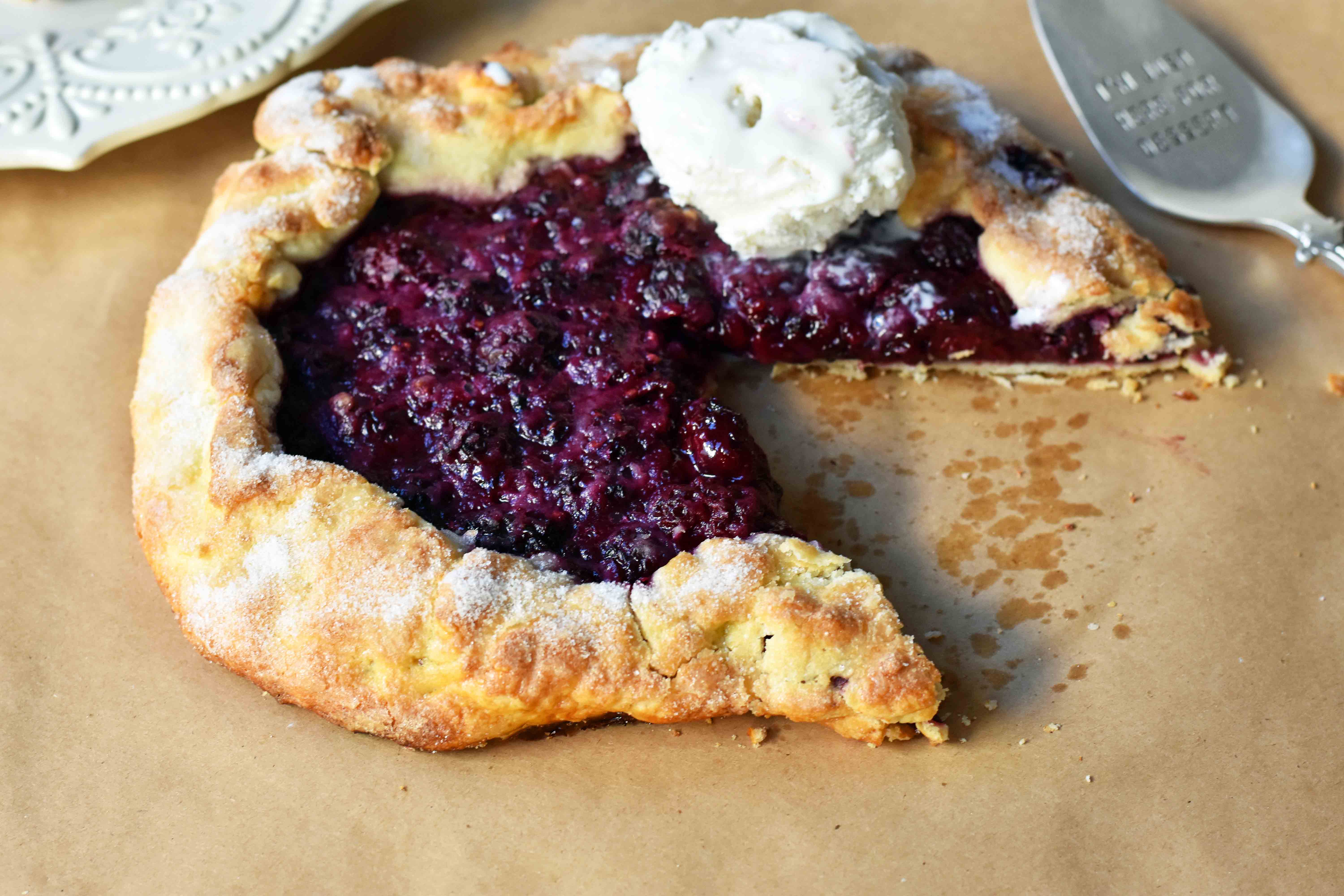 Blackberry Galette Crostata. An easy rustic summer dessert made with homemade buttery flaky pie crust with a sweet blackberry filling topped with vanilla bean ice cream. A much easier blackberry pie! www.modernhoney.com #galette #crostata #blackberrycrostata #blackberrygalette #summerdessert #berrydessert