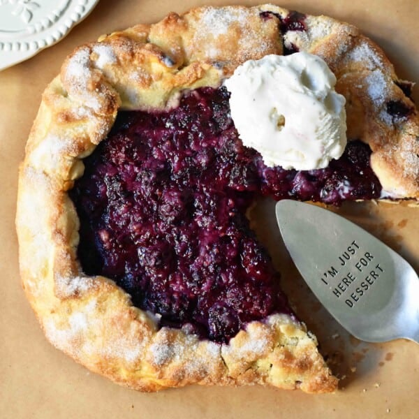 Blackberry Galette Crostata. An easy rustic summer dessert made with homemade buttery flaky pie crust with a sweet blackberry filling topped with vanilla bean ice cream. A much easier blackberry pie! www.modernhoney.com #galette #crostata #blackberrycrostata #blackberrygalette #summerdessert #berrydessert