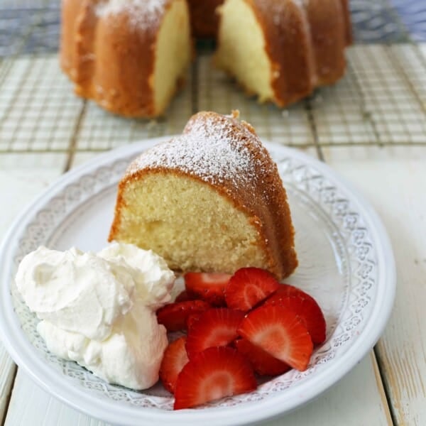 The BEST Cream Cheese Pound Cake with fresh strawberries and whipped cream. How to make the perfect pound cake in a bundt pan. Buttery cream cheese pound cake goes with everything! This is such a popular cake that is wonderful on its own or in a trifle or berry compote. www.modernhoney.com #poundcake #bundtcake #cake #creamcheesecake