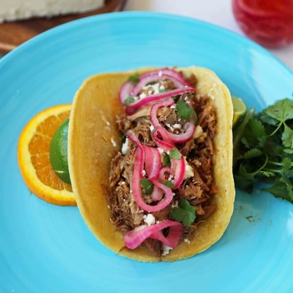 Mexican Pork Carnitas Tacos. Slow Cooker Pork Carnitas with Pickled Onions. How to make tender and flavorful pork carnitas slow cooked in Coca-Cola and citrus juices. www.modernhoney.com #tacos #carnitas #porkcarnitas #slowcooker #slowcookercarnitas