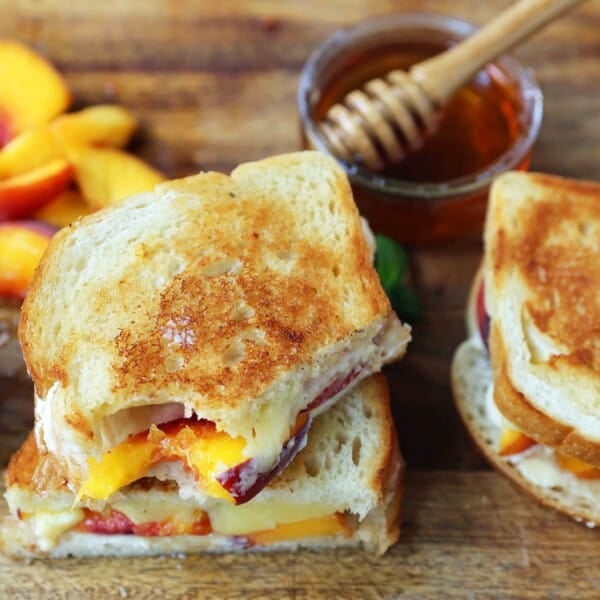 Honey Peach White Cheddar Grilled Cheese Sandwich. A summer grilled cheese sandwich with sweet juicy peaches, white cheddar cheese, a drizzle of honey on buttery toasted bread. www.modernhoney.com #peaches #grilledcheese #peachgrilledcheese