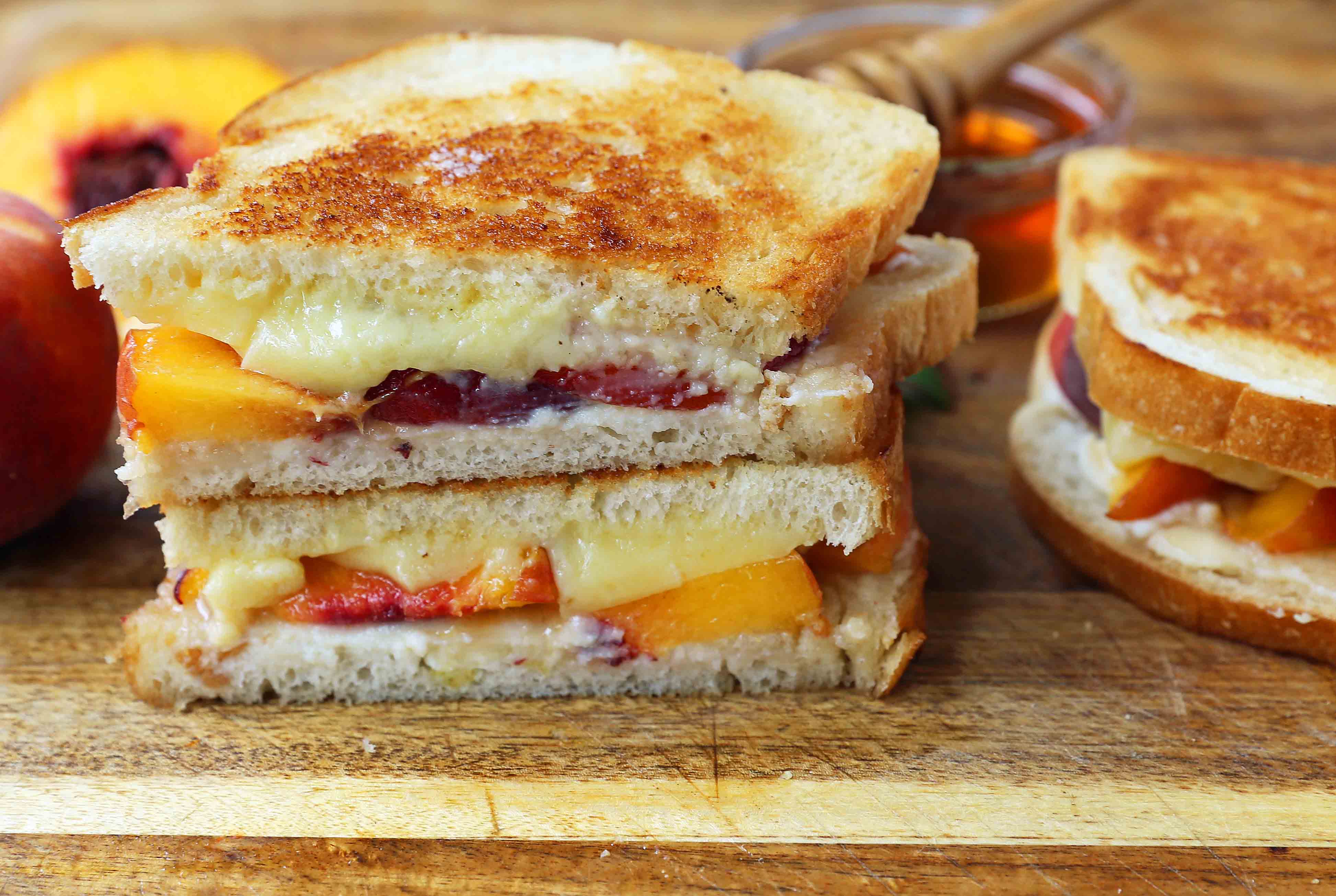 Honey Peach White Cheddar Grilled Cheese Sandwich. A summer grilled cheese sandwich with sweet juicy peaches, white cheddar cheese, a drizzle of honey on buttery toasted bread. www.modernhoney.com #peaches #grilledcheese #peachgrilledcheese 