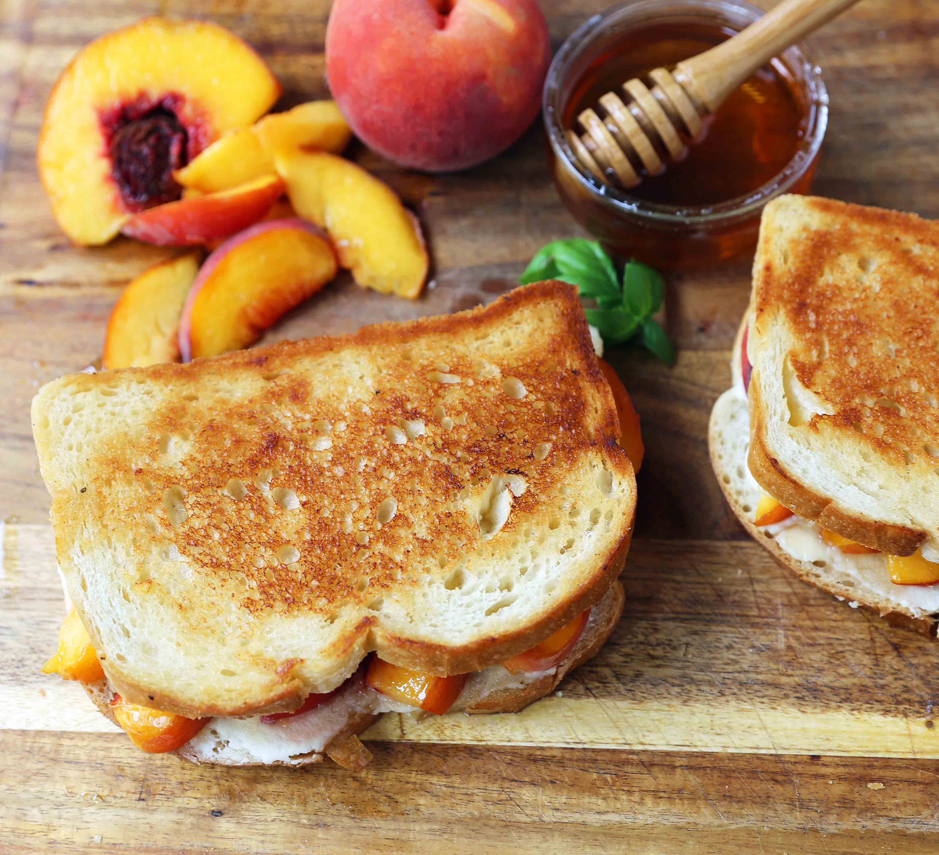 Honey Peach White Cheddar Grilled Cheese Sandwich. A summer grilled cheese sandwich with sweet juicy peaches, white cheddar cheese, a drizzle of honey on buttery toasted bread. www.modernhoney.com #peaches #grilledcheese #peachgrilledcheese 