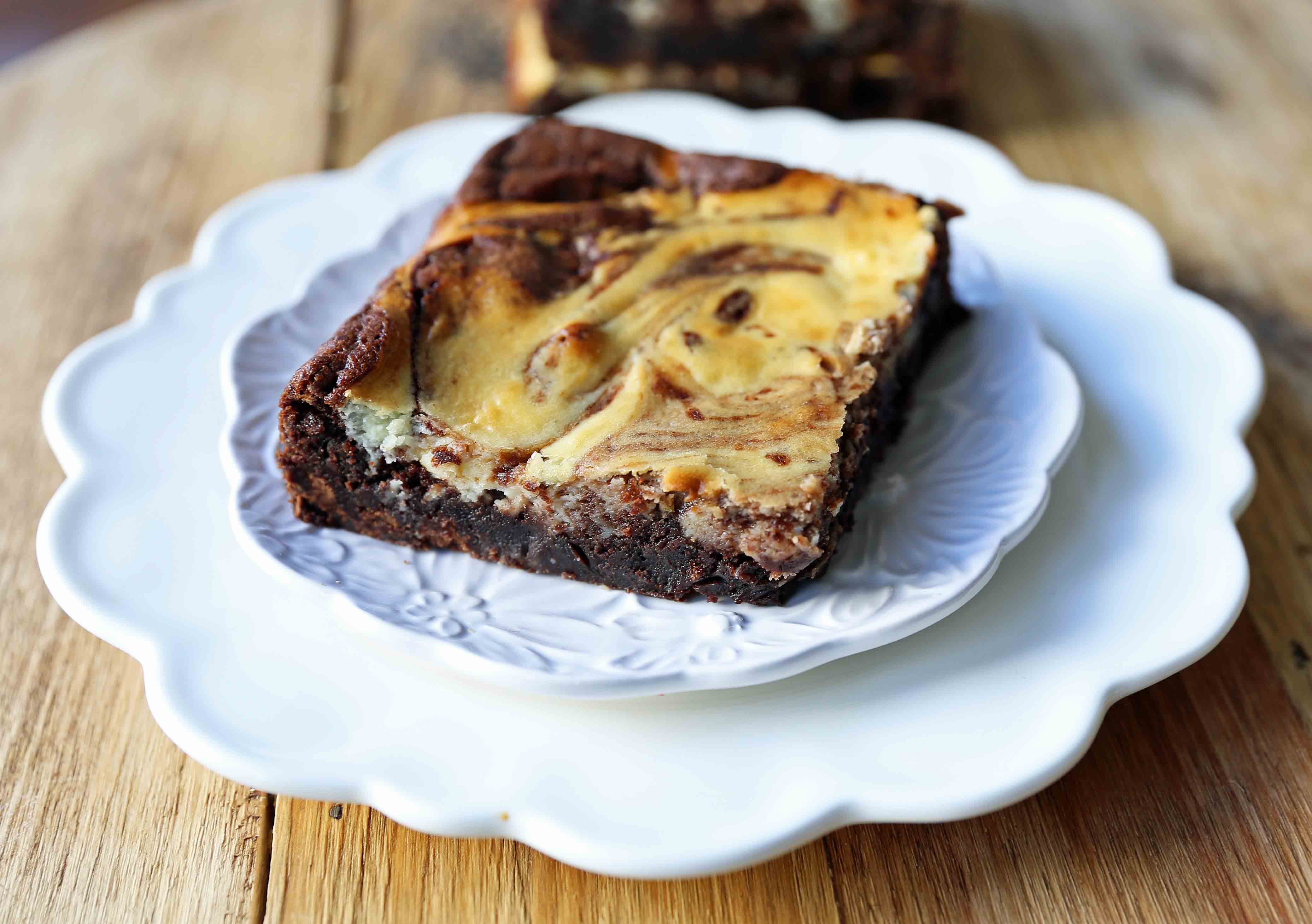 Cheesecake Brownies Homemade double chocolate chunk brownies with a sweet and tangy cheesecake swirl. Cheesecake and a Brownie in one dessert bar! Cream Cheese Brownies Recipe. www.modernhoney.com #creamcheesebrownies #cheesecakebrownies #brownies #cheesecakebrownierecipe #homemadebrownies