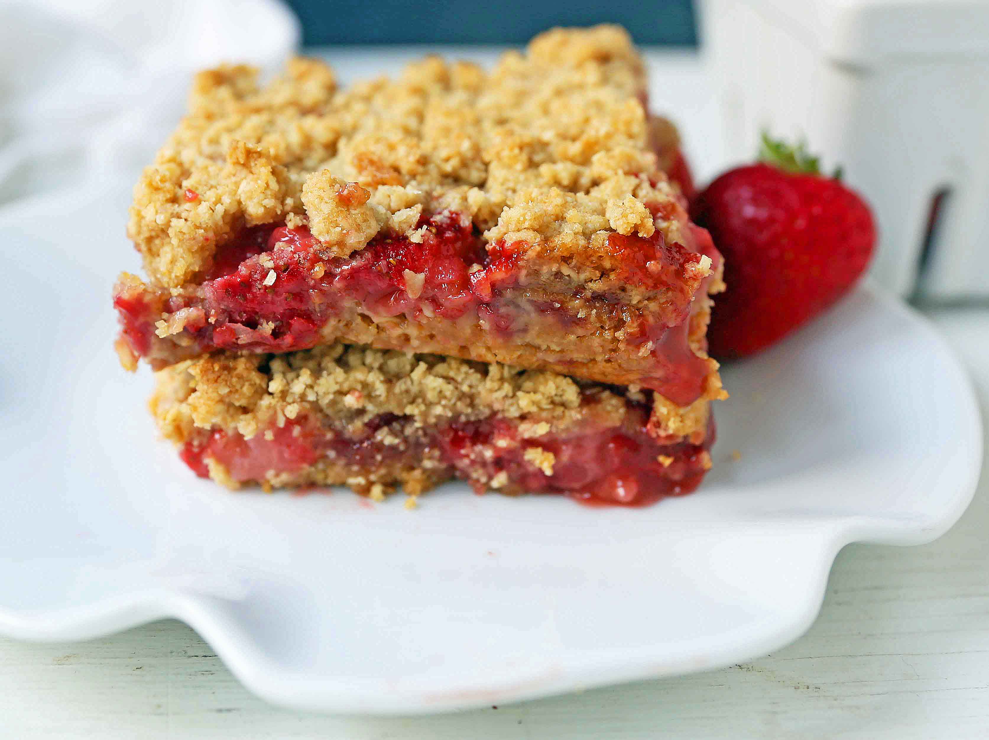 Strawberry Oat Crumble Bars Recipe. Homemade Strawberry Crumble Bars. The perfect Summer dessert bar using fresh strawberries. Strawberry Oatmeal Crumble Bars are made with a buttery oatmeal crust and a fresh strawberries and jam filling. www.modernhoney.com #strawberrybars @strawberryoatbars #strawberryoatmealbars #strawberryrecipes