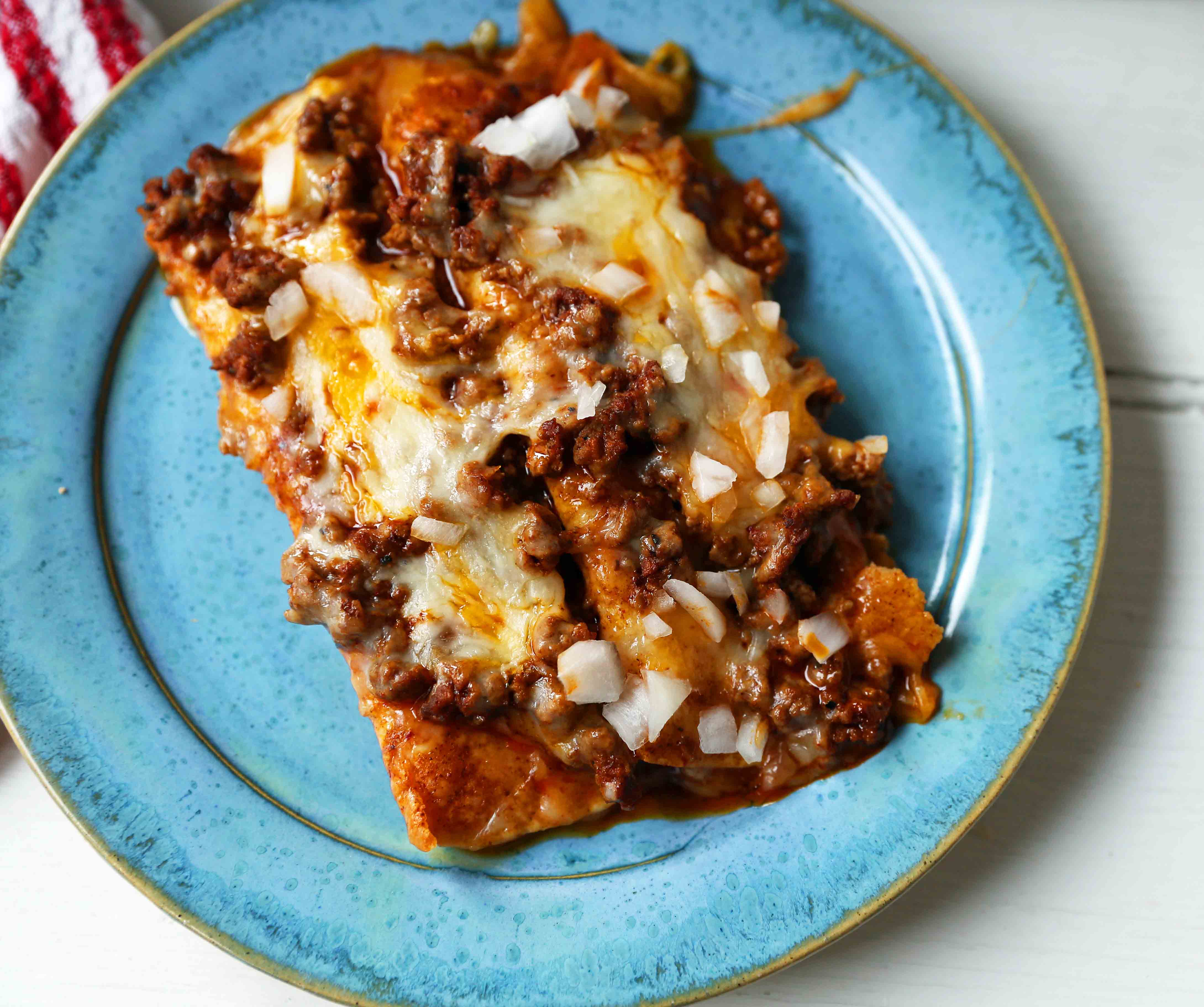 Chile con Carne Enchiladas. Authenic Tex-Mex Beef Enchiladas Recipe. Cheese Enchiladas topped with homemade chile con carne. The best chile con carne enchiladas recipe! #chiliconcarne #texmex #texmexenchiladas #enchiladas #mexicanfood