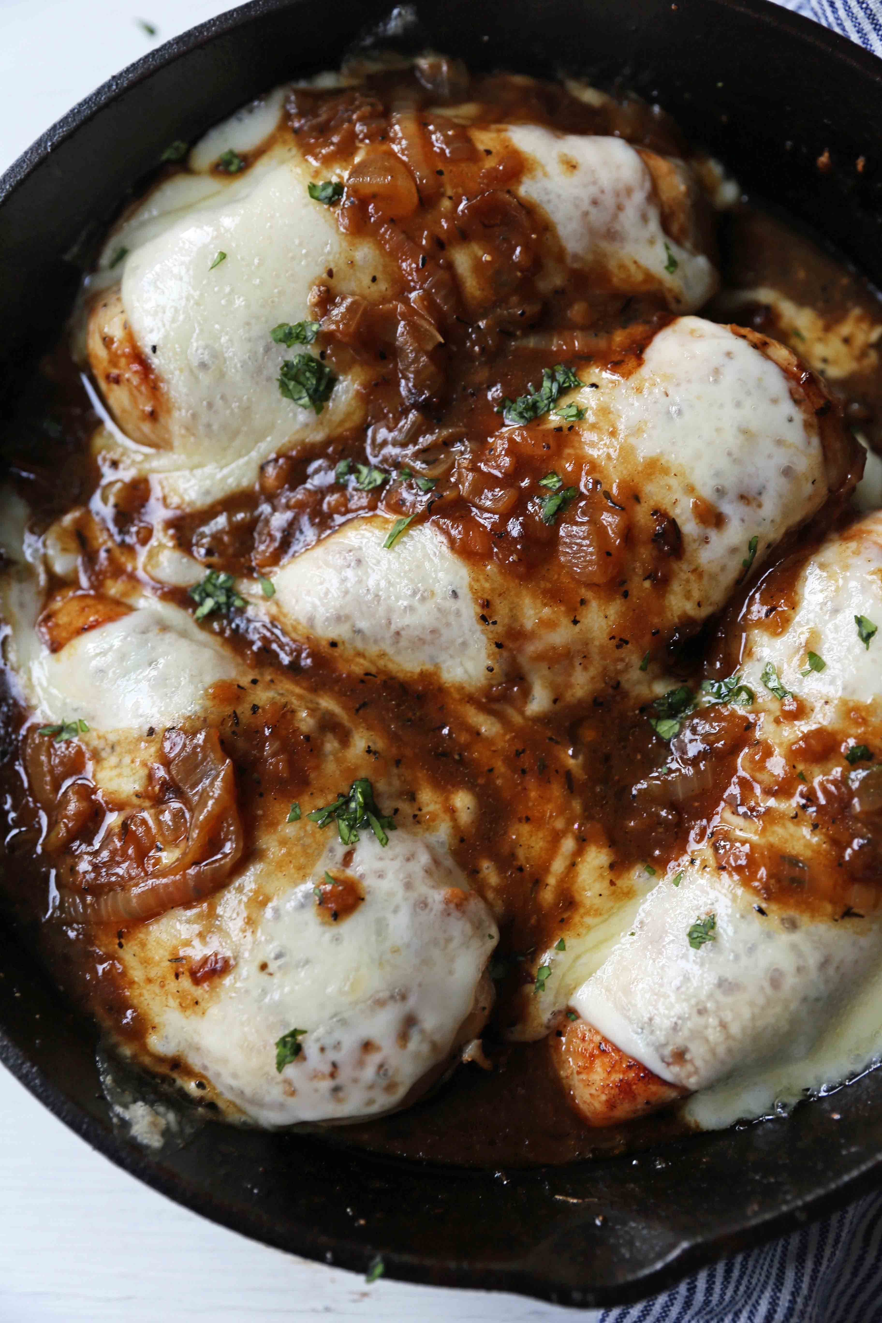 French Onion Chicken Skillet Chicken with Buttery Caramelized Onion Gravy and Melted Cheeses. A simple, flavorful, 30-minute meal! www.modernhoney.com #30minutemeal #dinnerrecipe #frenchonionchicken #cheesychicken #chickendinner