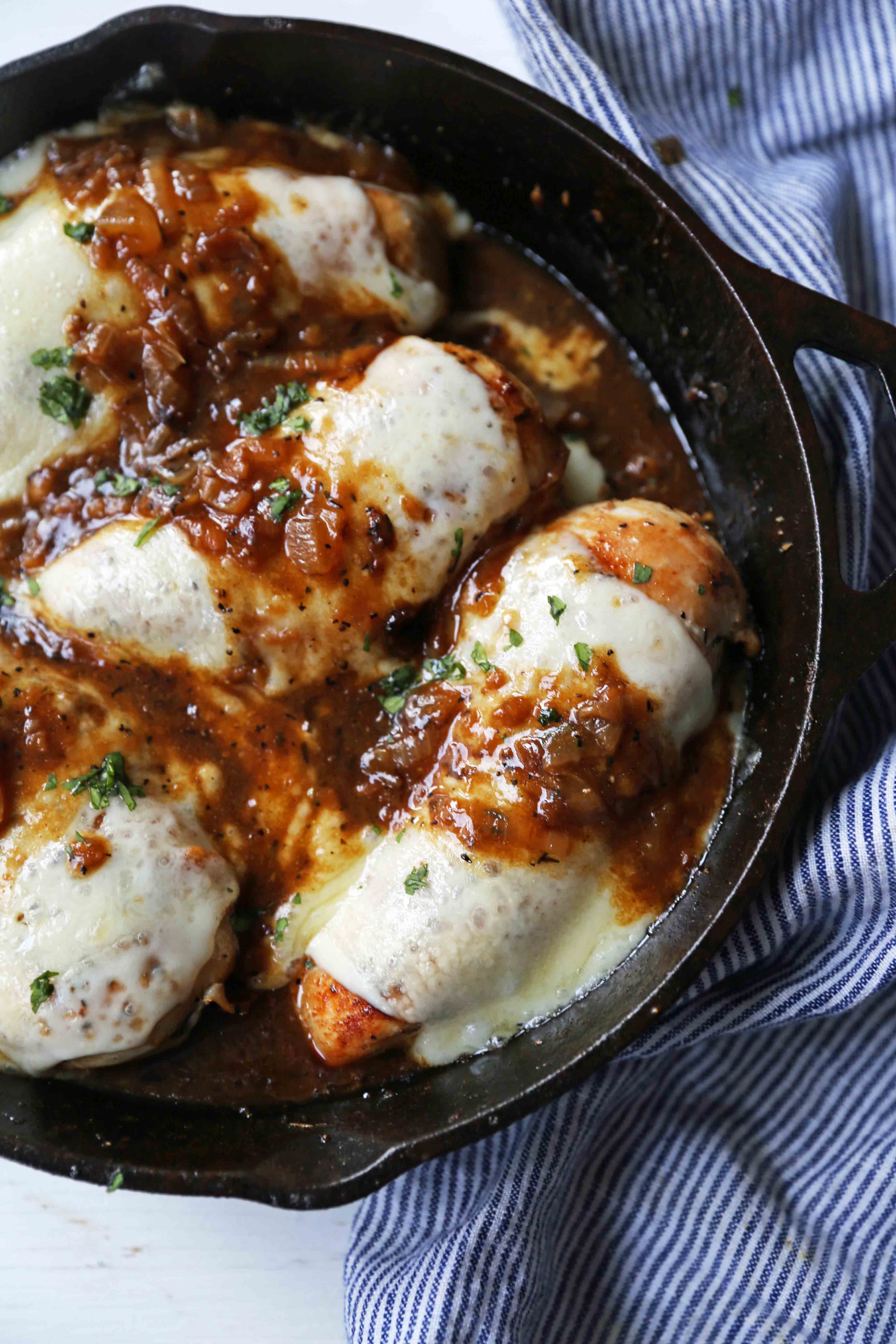 French Onion Chicken Skillet Chicken with Buttery Caramelized Onion Gravy and Melted Cheeses. A simple, flavorful, 30-minute meal! www.modernhoney.com #30minutemeal #dinnerrecipe #frenchonionchicken #cheesychicken #chickendinner