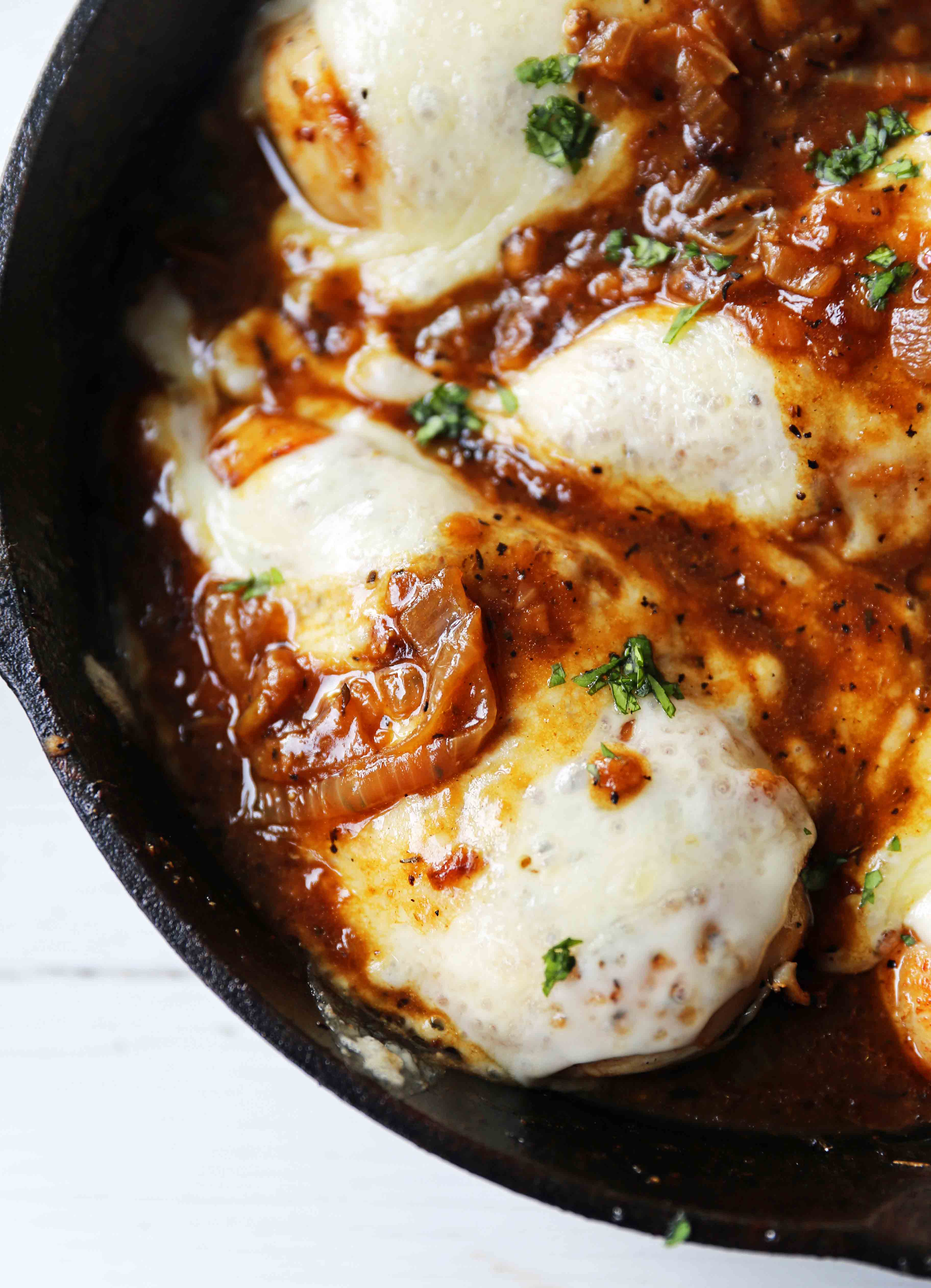 French Onion Chicken Skillet Chicken with Buttery Caramelized Onion Gravy and Melted Cheeses. A simple, flavorful, 30-minute meal! www.modernhoney.com #30minutemeal #dinnerrecipe #frenchonionchicken #cheesychicken #chickendinner