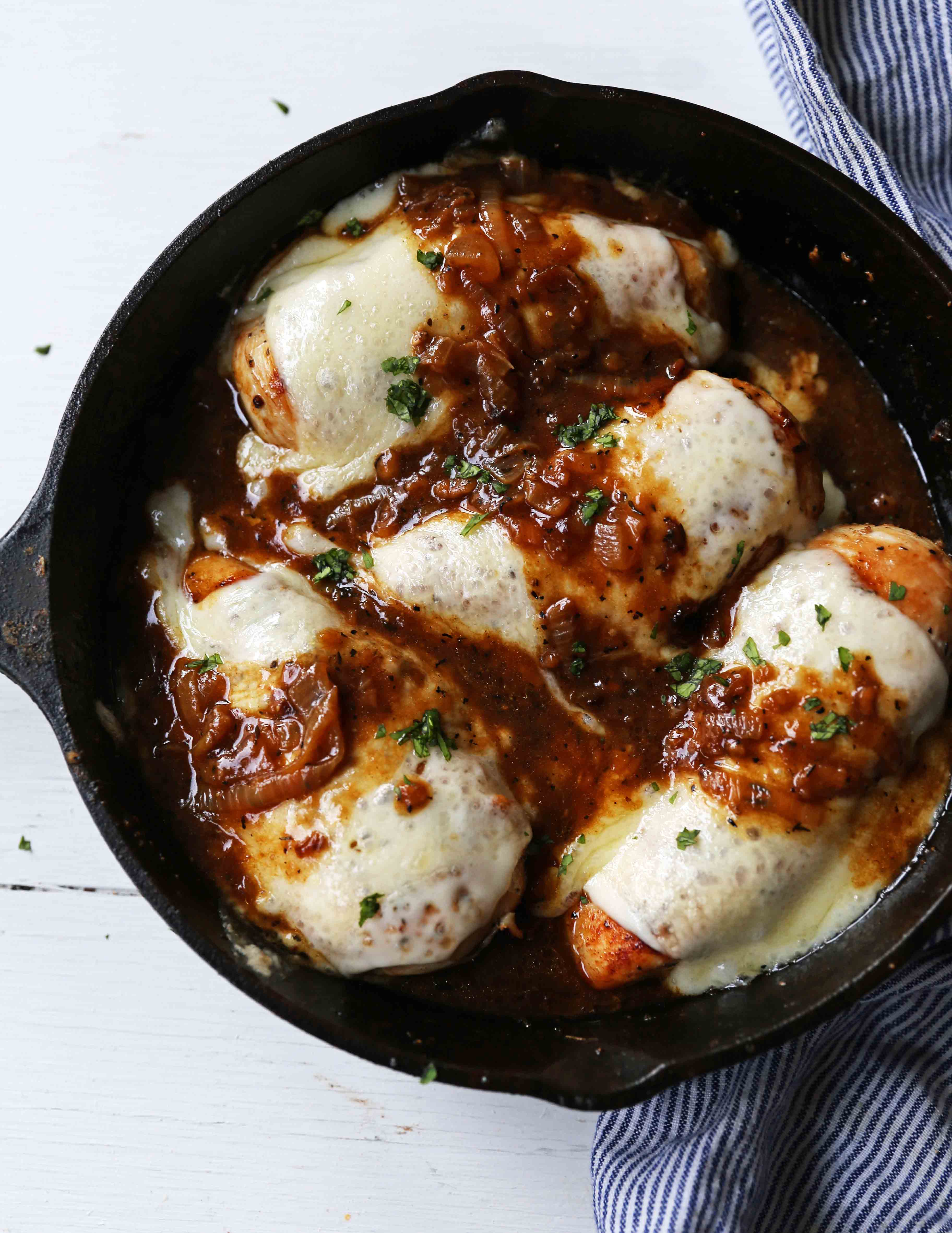 French Onion Chicken Skillet Chicken with Buttery Caramelized Onion Gravy and Melted Cheeses. A simple, flavorful, 30-minute meal! www.modernhoney.com #30minutemeal #dinnerrecipe #frenchonionchicken #cheesychicken #chickendinner