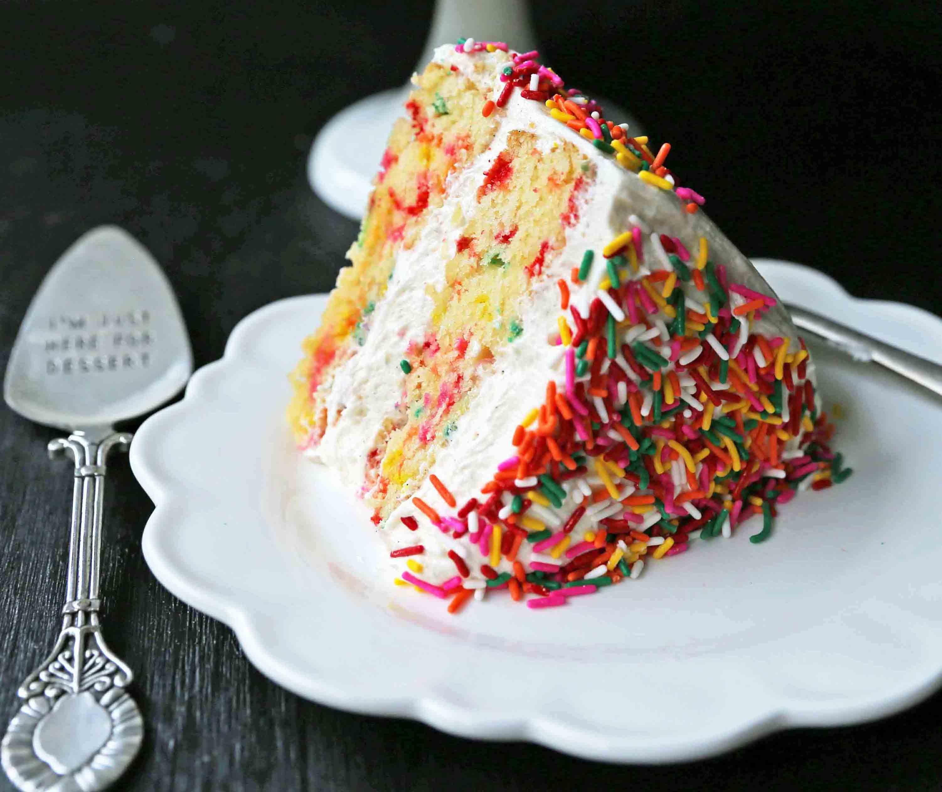 A fluffy homemade funfetti birthday cake with rainbow sprinkles topped with a light cream cheese buttercream frosting and an array of sprinkles. The perfect birthday cake! www.modernhoney.com #funfetti #funfetticake #sprinklescake #homemadefunfetticake #cake #homemadecake
