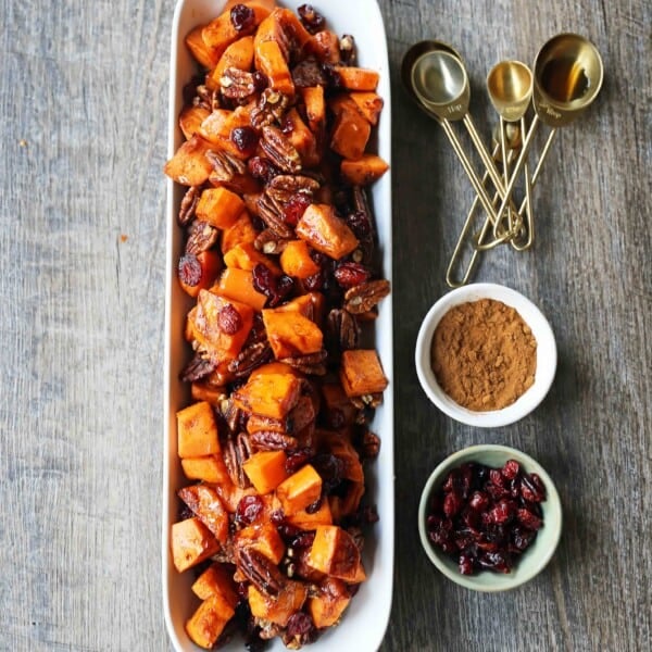 Roasted Sweet Potatoes with Pecans and Cranberries An easy, healthy side dish made with cinnamon roasted sweet potatoes, toasted pecans, and sweet and tart dried cranberries. www.modernhoney.com #sidedish #sweetpotatoes #sweetpotatoespecan #roastedsweetpotatoes