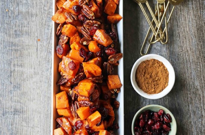 Roasted Sweet Potatoes with Pecans and Cranberries An easy, healthy side dish made with cinnamon roasted sweet potatoes, toasted pecans, and sweet and tart dried cranberries. www.modernhoney.com #sidedish #sweetpotatoes #sweetpotatoespecan #roastedsweetpotatoes