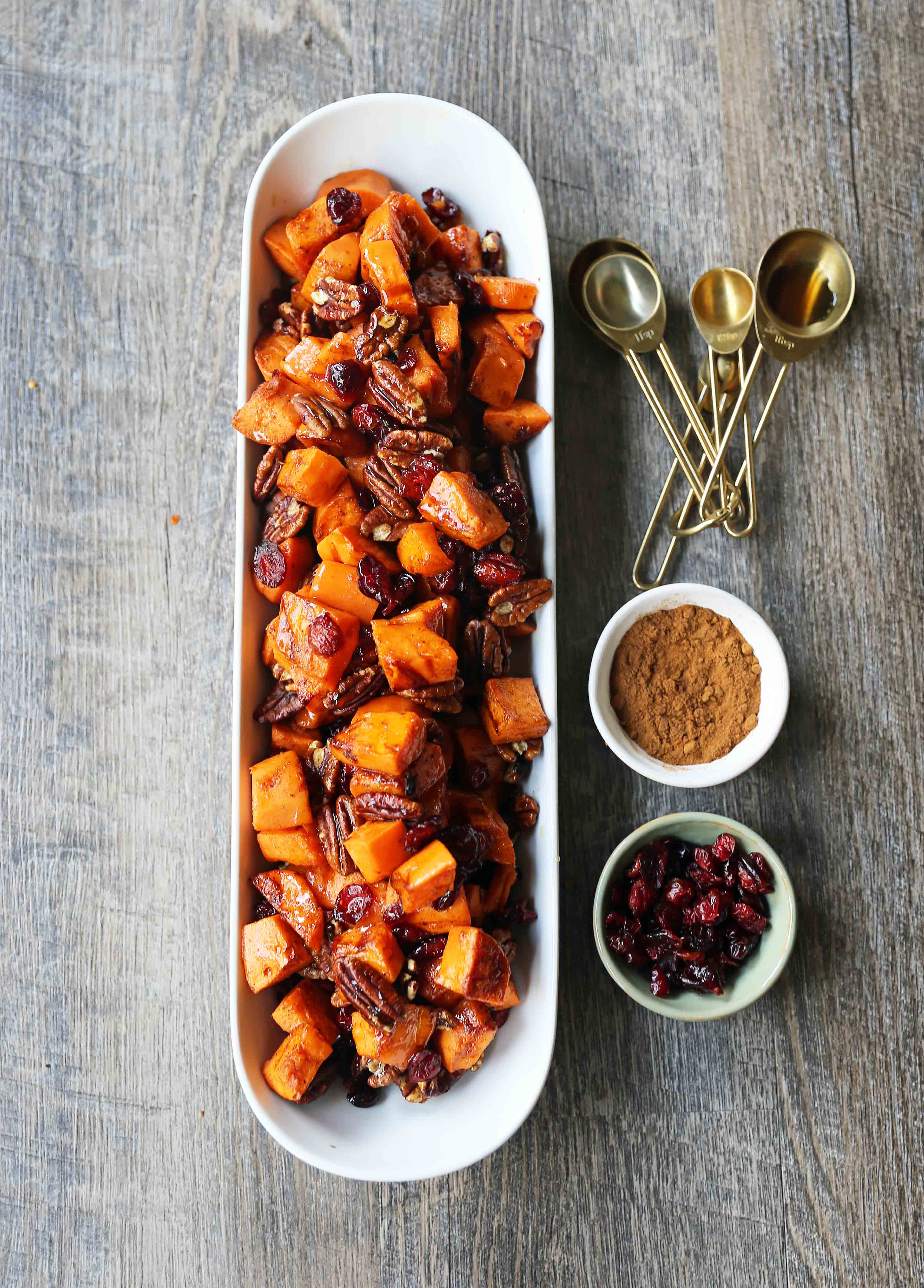 Roasted Sweet Potatoes with Pecans and Cranberries An easy, healthy side dish made with cinnamon roasted sweet potatoes, toasted pecans, and sweet and tart dried cranberries. www.modernhoney.com #sidedish #sweetpotatoes #sweetpotatoespecan #roastedsweetpotatoes