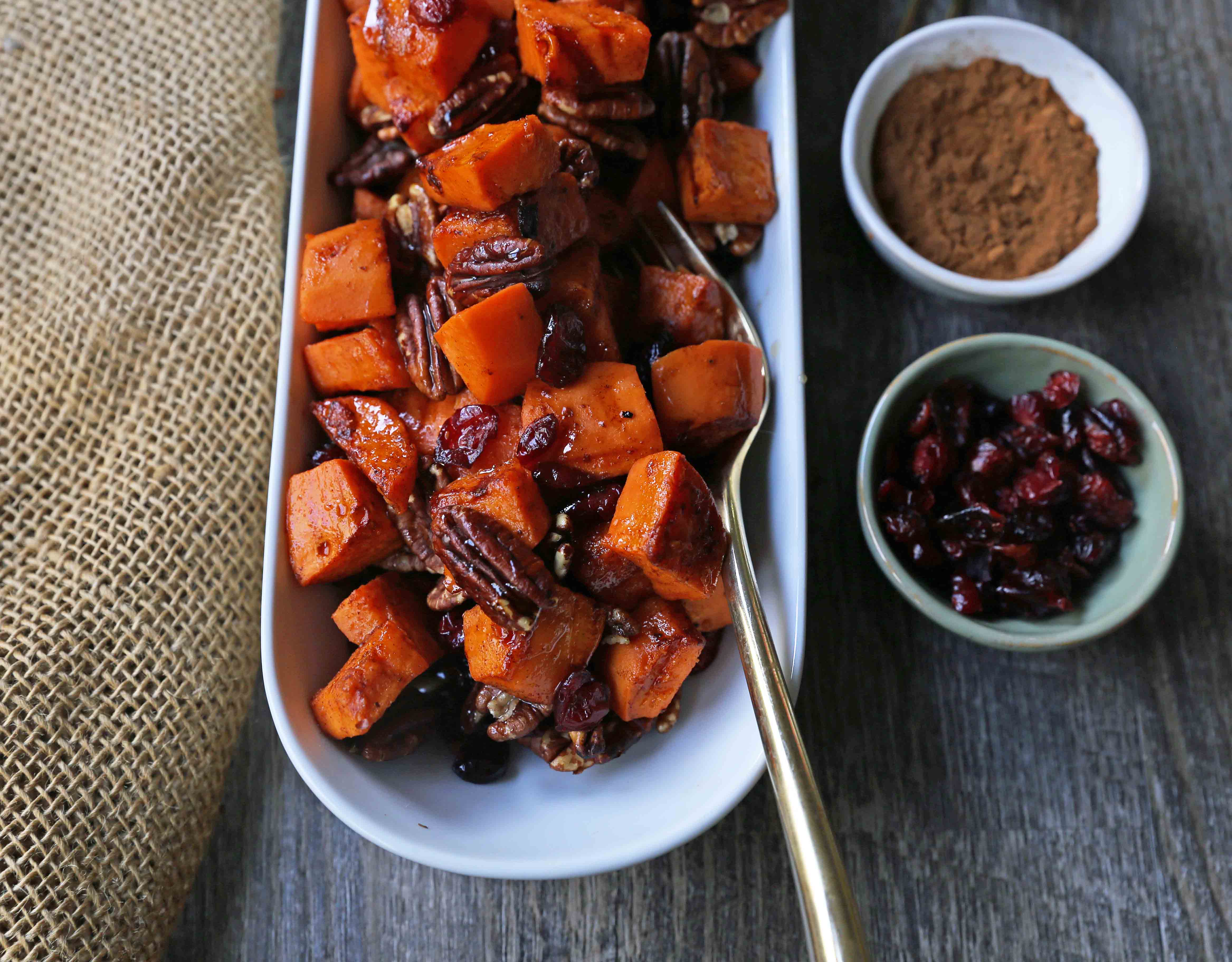 Roasted Sweet Potatoes with Pecans and Cranberries An easy, healthy side dish made with cinnamon roasted sweet potatoes, toasted pecans, and sweet and tart dried cranberries. www.modernhoney.com #sidedish #sweetpotatoes #sweetpotatoespecan #roastedsweetpotatoes