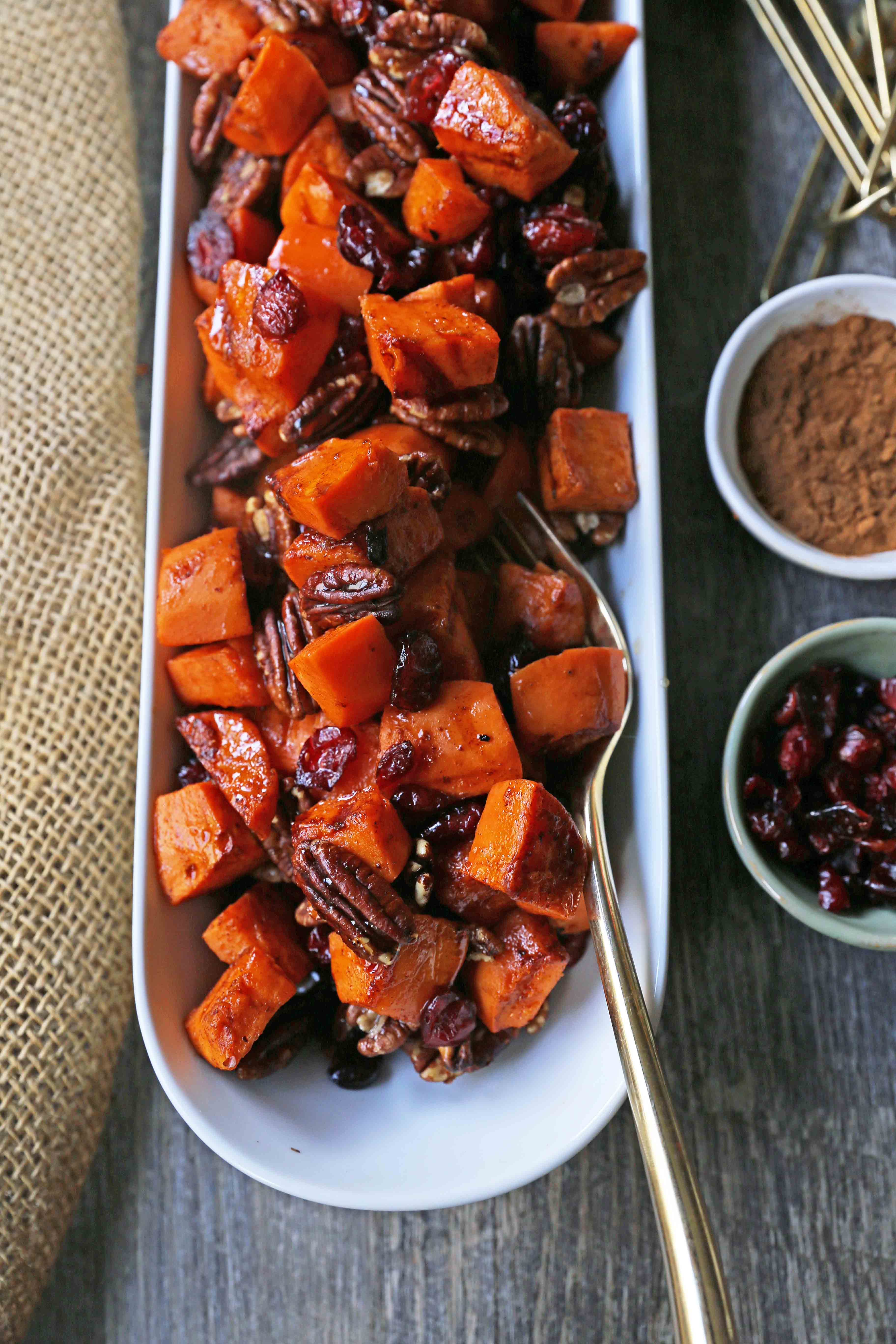 Roasted Sweet Potatoes with Pecans and Cranberries An easy, healthy side dish made with cinnamon roasted sweet potatoes, toasted pecans, and sweet and tart dried cranberries. www.modernhoney.com #sidedish #sweetpotatoes #sweetpotatoespecan #roastedsweetpotatoes