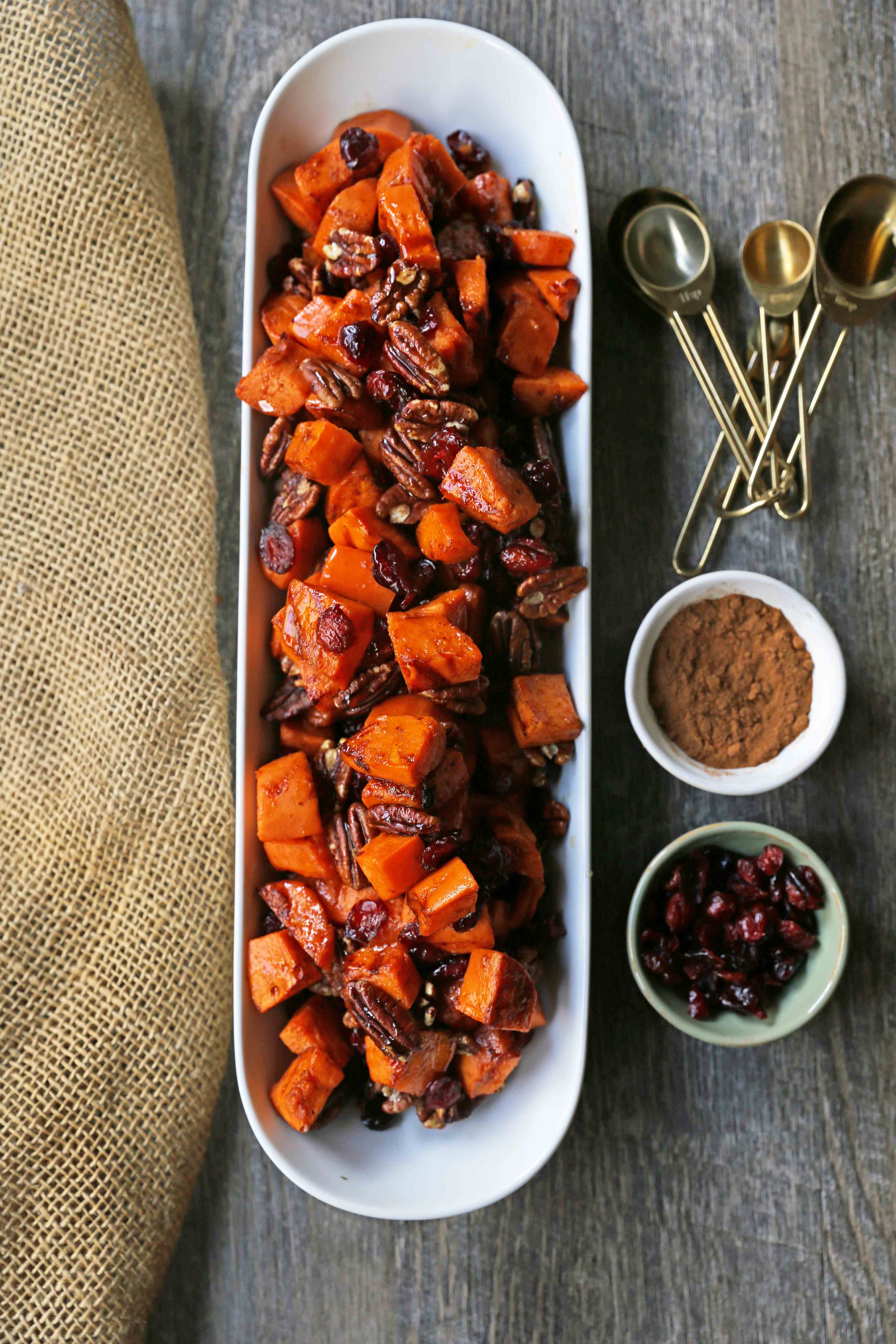 Roasted Sweet Potatoes with Pecans and Cranberries An easy, healthy side dish made with cinnamon roasted sweet potatoes, toasted pecans, and sweet and tart dried cranberries. www.modernhoney.com #sidedish #sweetpotatoes #sweetpotatoespecan #roastedsweetpotatoes