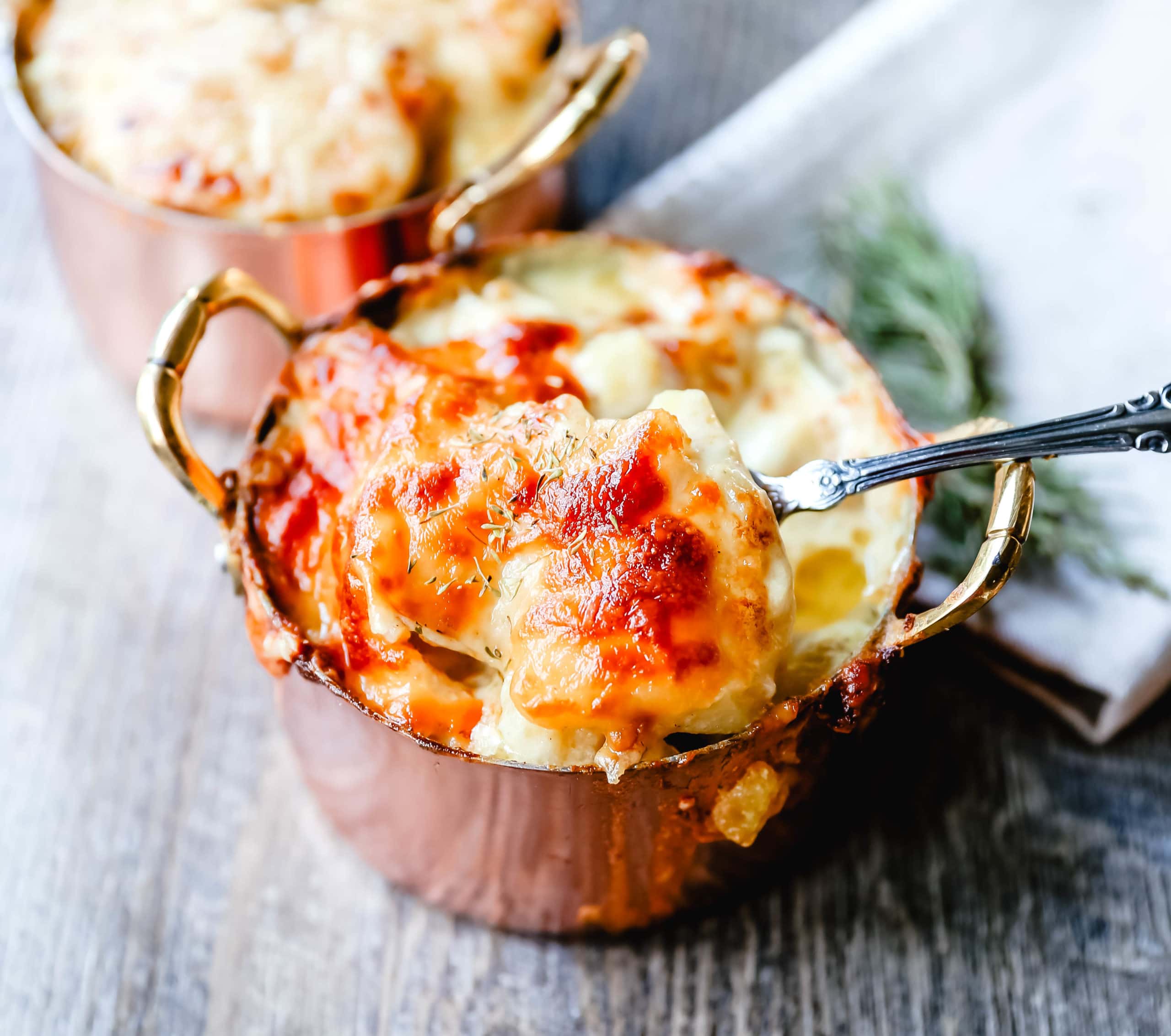 Cheesy Potatoes Au Gratin Homemade cheesy scalloped potatoes with a rich cream sauce and melted cheddar cheese. The perfect potato side dish recipe! www.modernhoney.com #scallopedpotatoes #augratinpotatoes #cheesypotatoes #potatoesaugratin