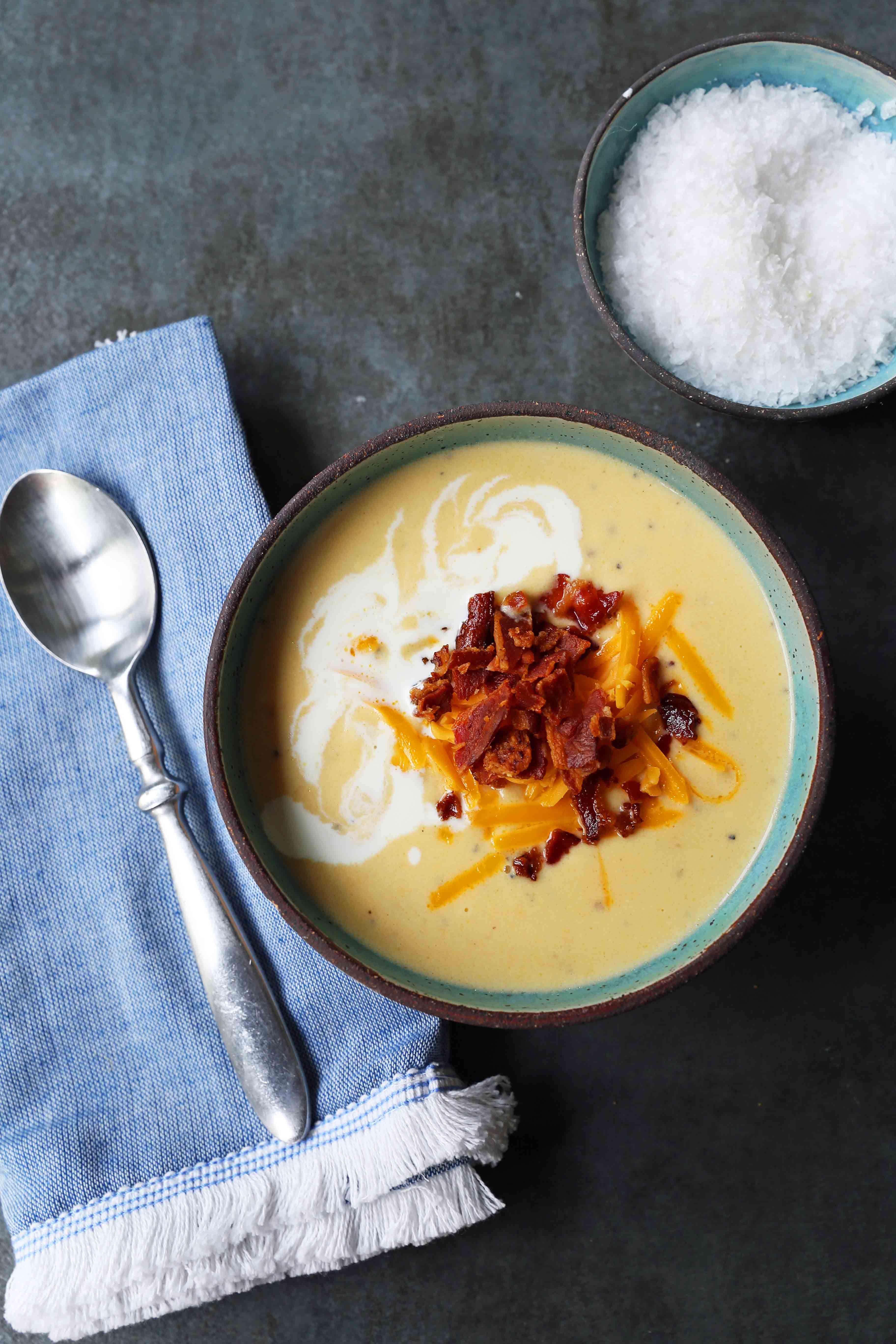 Cheesy Cauliflower Soup. A creamy cheesy cauliflower soup made with fresh cauliflower, cream, sharp cheddar cheese, and bacon. A velvety smooth cream of cauliflower soup will become a winter staple in your home! www.modernhoney.com #cauliflowersoup #cheesycauliflowersoup #creamofcauliflowersoup #soup #souprecipes