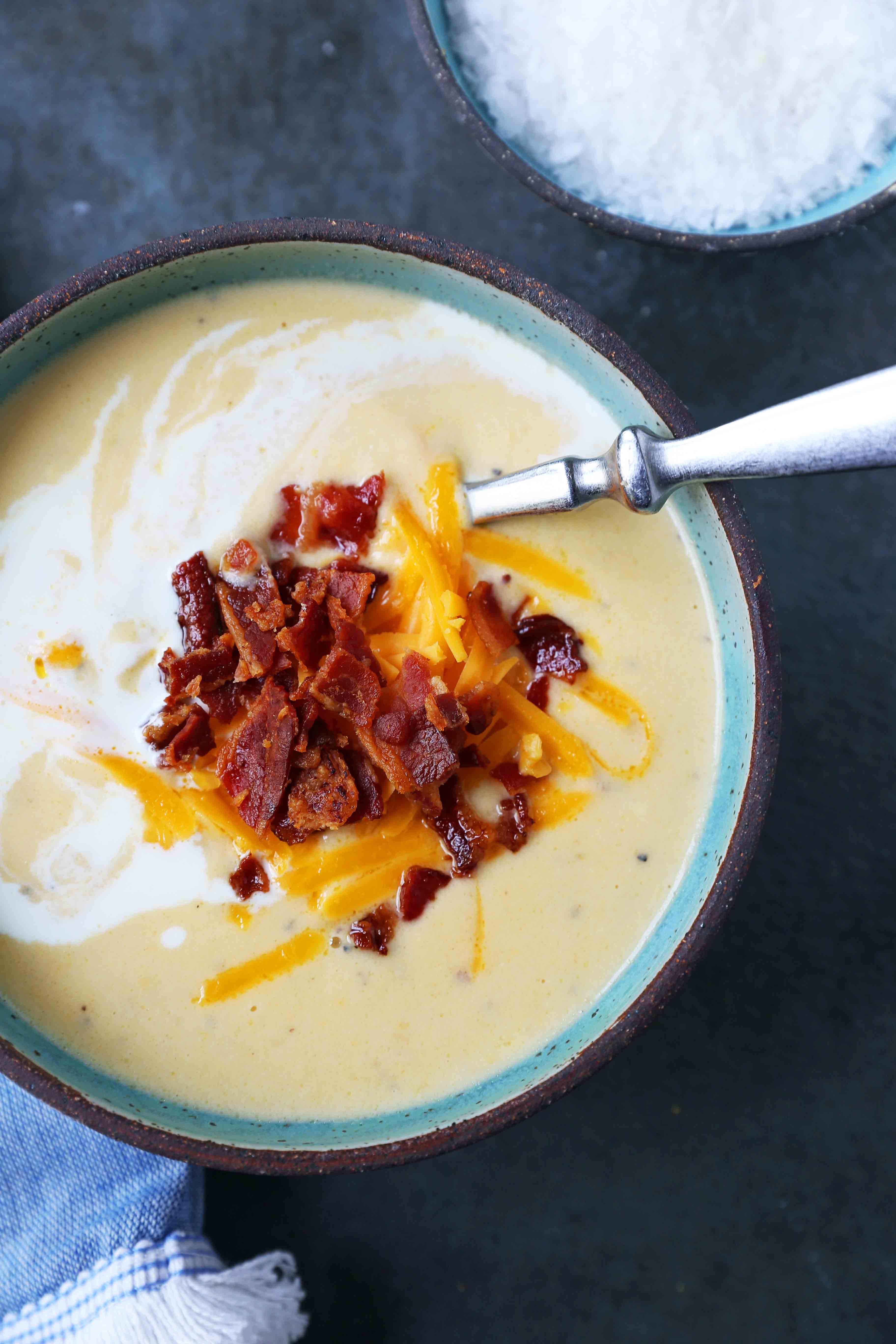 Cheesy Cauliflower Soup. A creamy cheesy cauliflower soup made with fresh cauliflower, cream, sharp cheddar cheese, and bacon. A velvety smooth cream of cauliflower soup will become a winter staple in your home! www.modernhoney.com #cauliflowersoup #cheesycauliflowersoup #creamofcauliflowersoup #soup #souprecipes