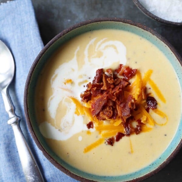 Cheesy Cauliflower Soup. A creamy cheesy cauliflower soup made with fresh cauliflower, cream, sharp cheddar cheese, and bacon. A velvety smooth cream of cauliflower soup will become a winter staple in your home! www.modernhoney.com #cauliflowersoup #cheesycauliflowersoup #creamofcauliflowersoup #soup #souprecipes