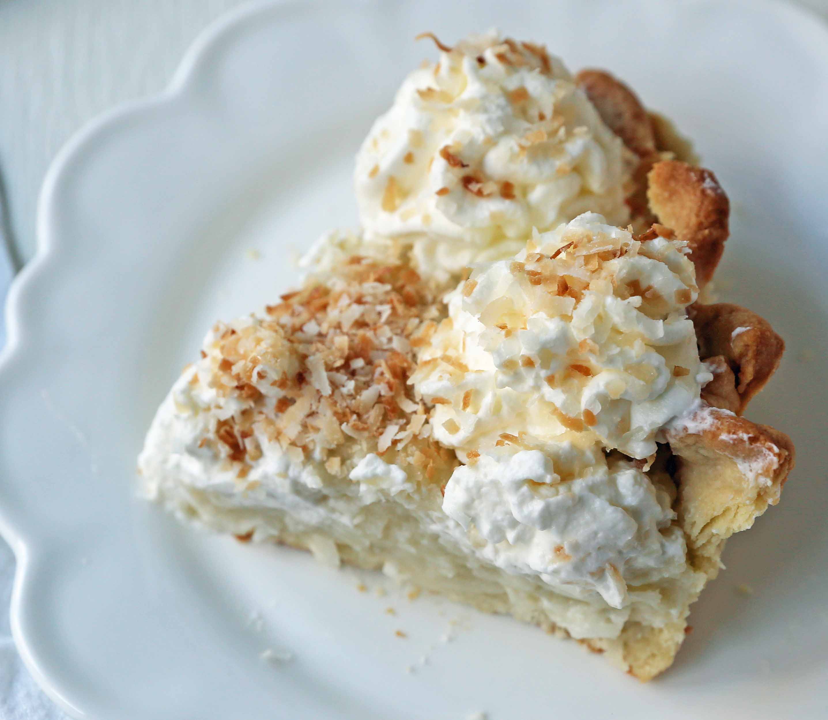 Coconut Cream Pie. A homemade coconut custard filling in a buttery pie crust topped with fresh whipped cream and toasted coconut. www.modernhoney.com #coconutcreampie #coconutpie #pie 