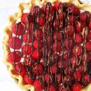 Raspberry Almond Cream Cheese Pie. A simple cream cheese almond pie with fresh raspberries and chocolate drizzle. An award-winning easy pie recipe! www.modernhoney.com #creamcheesepie #raspberrypie #pie #pierecipe #driscolls