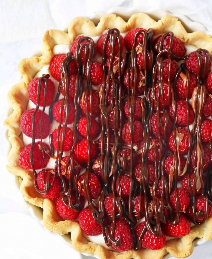 Raspberry Almond Cream Cheese Pie. A simple cream cheese almond pie with fresh raspberries and chocolate drizzle. An award-winning easy pie recipe! www.modernhoney.com #creamcheesepie #raspberrypie #pie #pierecipe #driscolls