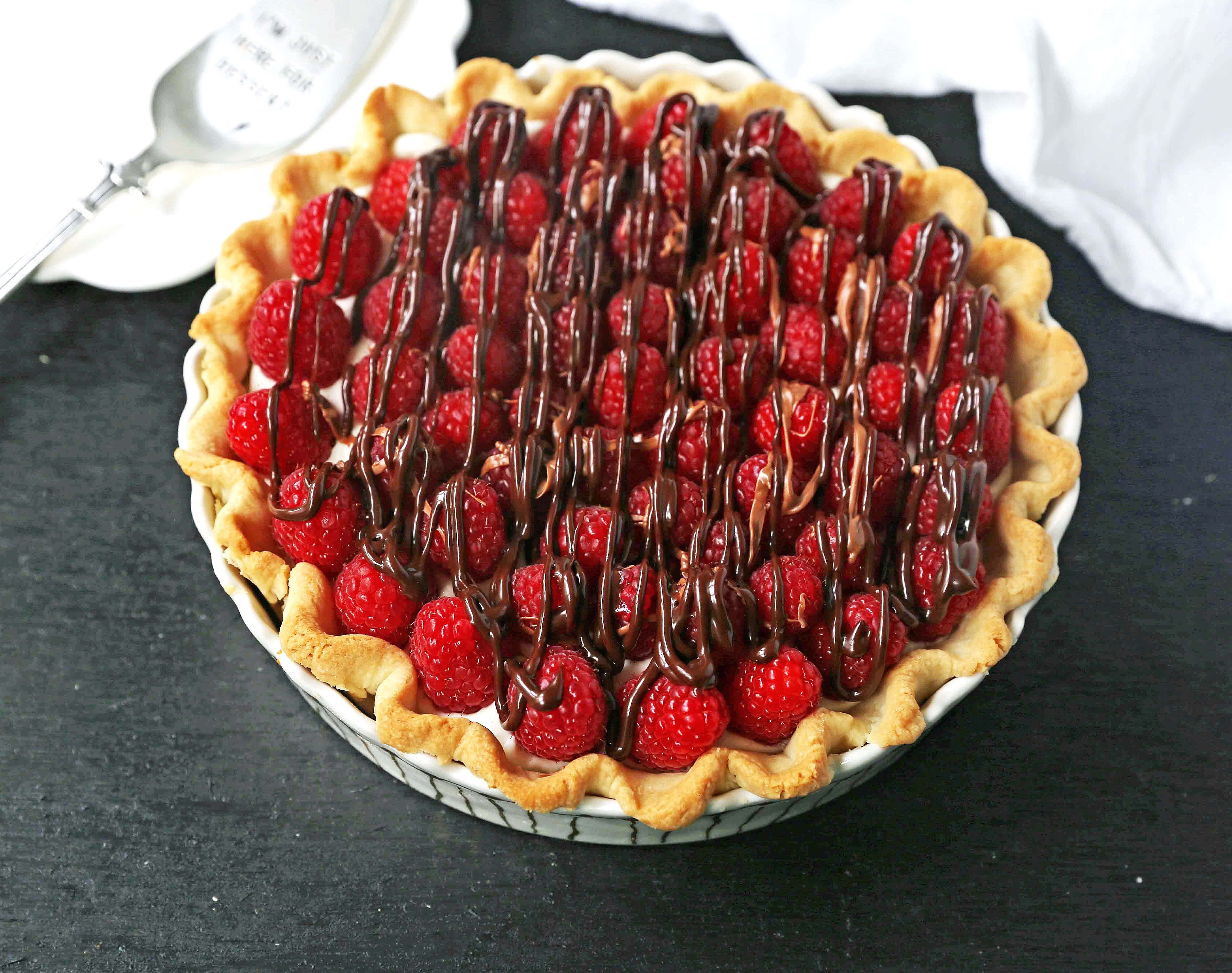 Raspberry Almond Cream Cheese Pie. A simple cream cheese almond pie with fresh raspberries and chocolate drizzle. An award-winning easy pie recipe! www.modernhoney.com #creamcheesepie #raspberrypie #pie #pierecipe #driscolls