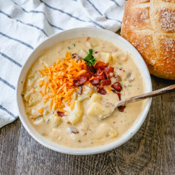 Loaded Baked Potato Soup is a rich and creamy potato cheese soup topped with crispy bacon, sour cream, green onions, and sharp cheddar cheese. A family favorite potato cheese soup recipe!