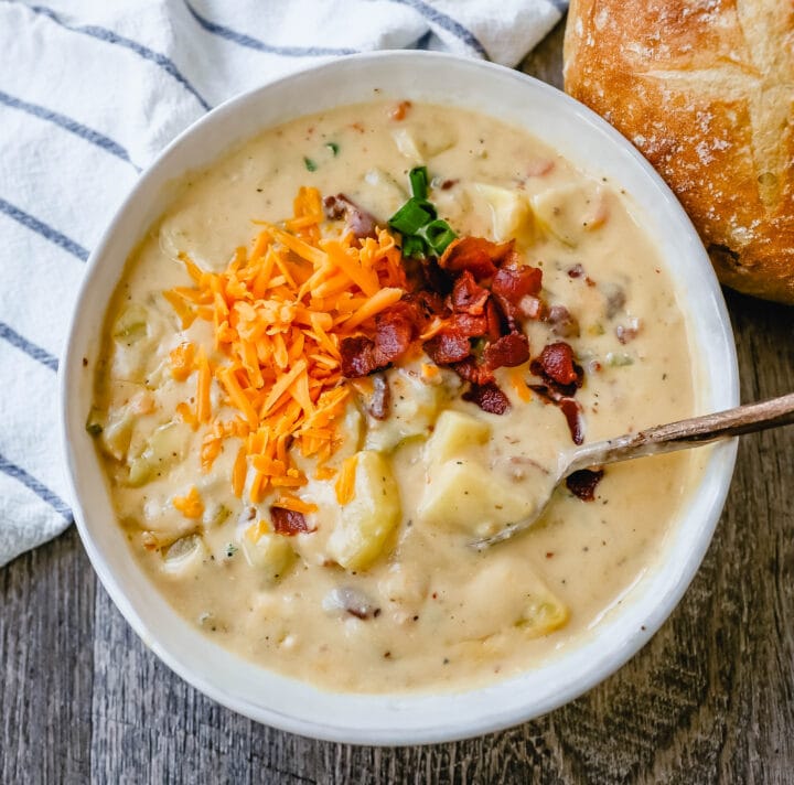 Loaded Baked Potato Soup is a rich and creamy potato cheese soup topped with crispy bacon, sour cream, green onions, and sharp cheddar cheese. A family favorite potato cheese soup recipe!