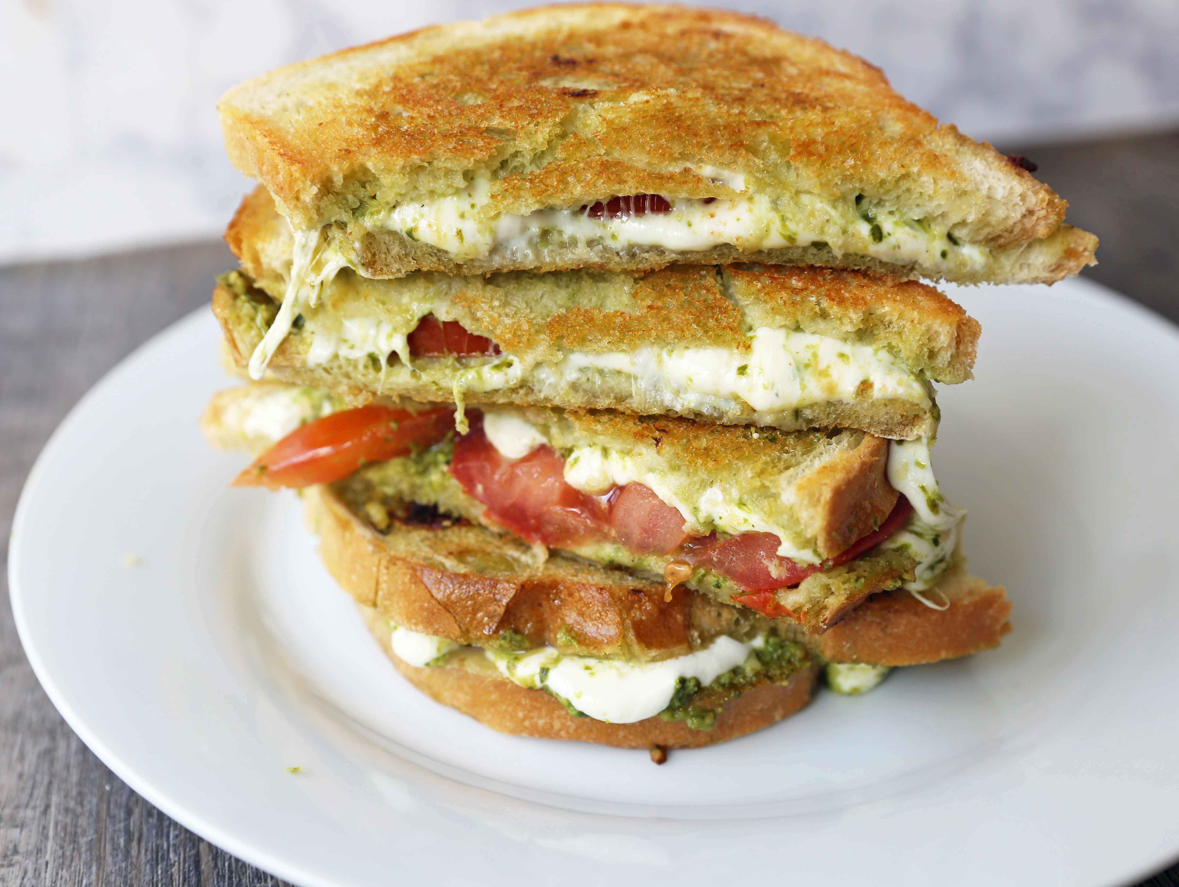 Pesto Panini with Fresh Mozzarella and Tomato. A toasted buttery panini with basil pesto, melted fresh mozzarella cheese, and juicy tomatoes. www.modernhoney.com #panini #sandwich #pesto #grilledsandwich