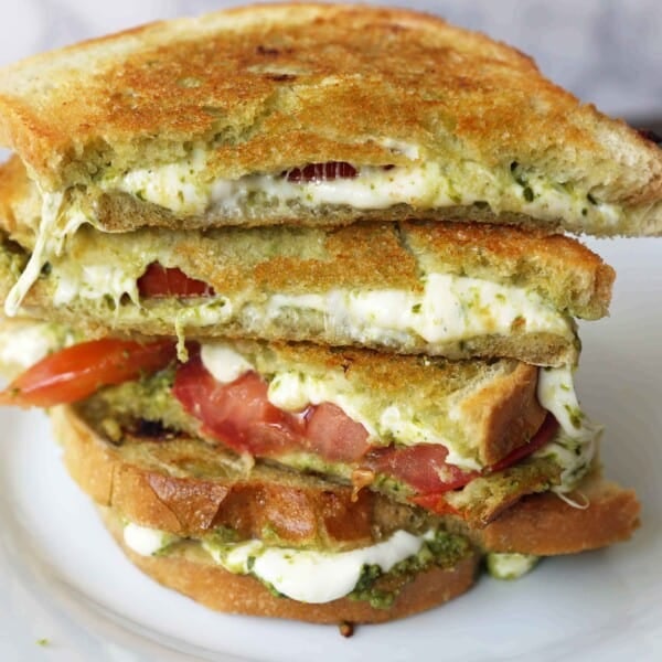 Pesto Panini with Fresh Mozzarella and Tomato. A toasted buttery panini with basil pesto, melted fresh mozzarella cheese, and juicy tomatoes. www.modernhoney.com #panini #sandwich #pesto #grilledsandwich