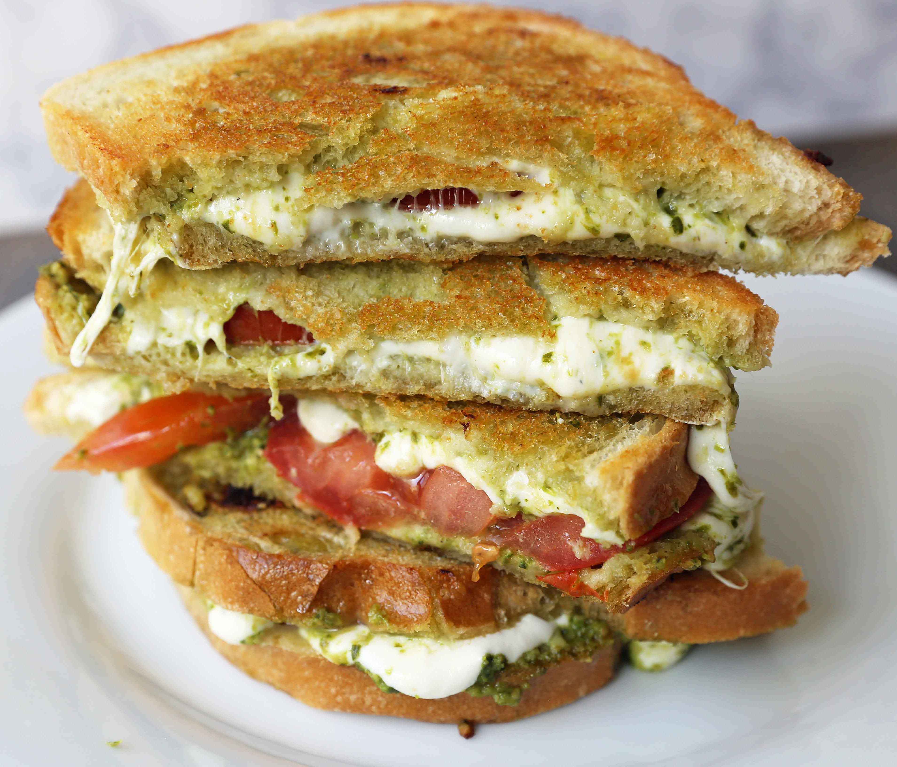 Pesto Panini with Fresh Mozzarella and Tomato. A toasted buttery panini with basil pesto, melted fresh mozzarella cheese, and juicy tomatoes. www.modernhoney.com #panini #sandwich #pesto #grilledsandwich