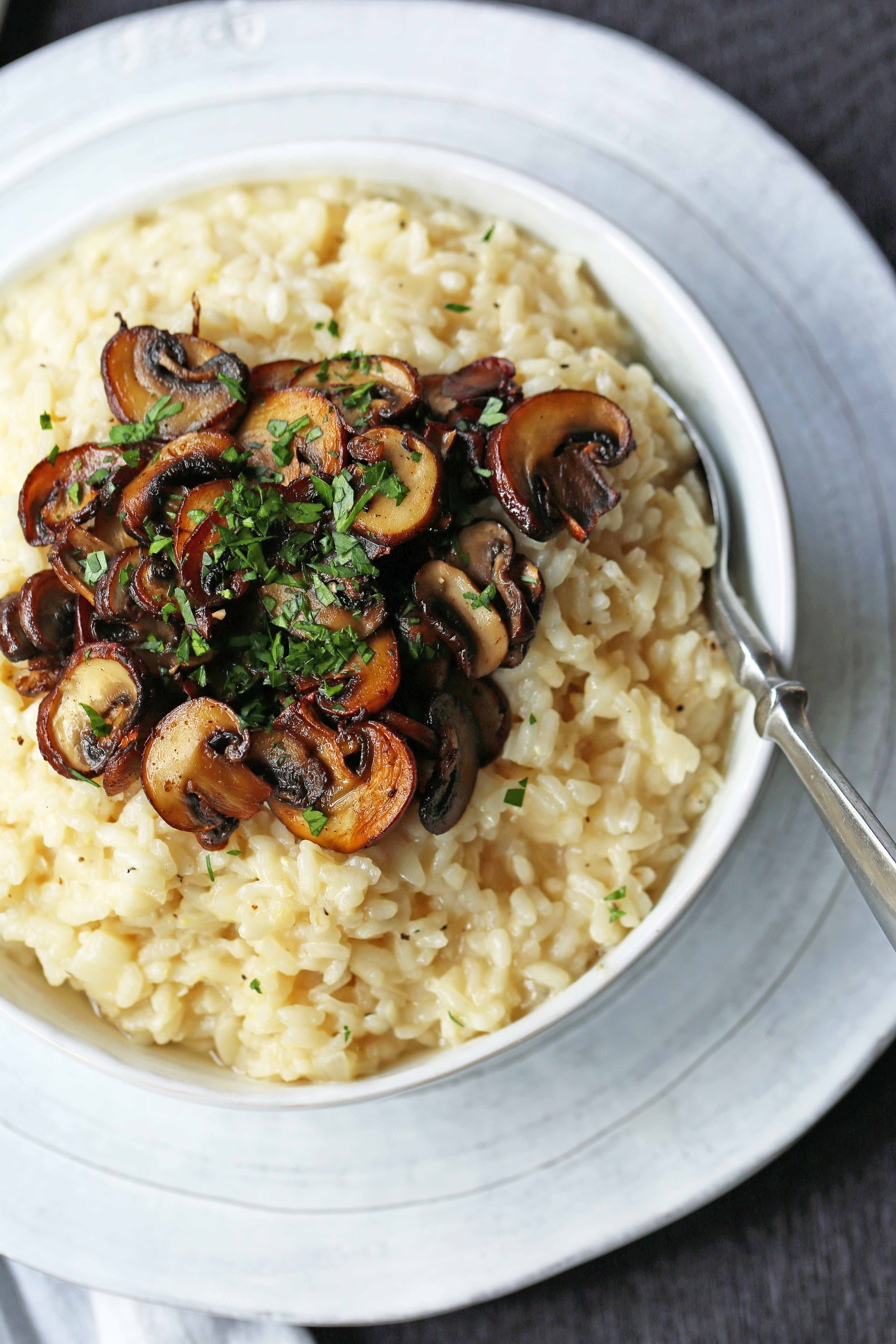 Creamy Mushroom Risotto. Rich, creamy rice slowly simmered with chicken broth, butter, parmesan cheese, and topped with butter sauteed mushrooms. www.modernhoney.com #risotto #homemaderisotto #mushroomrisotto