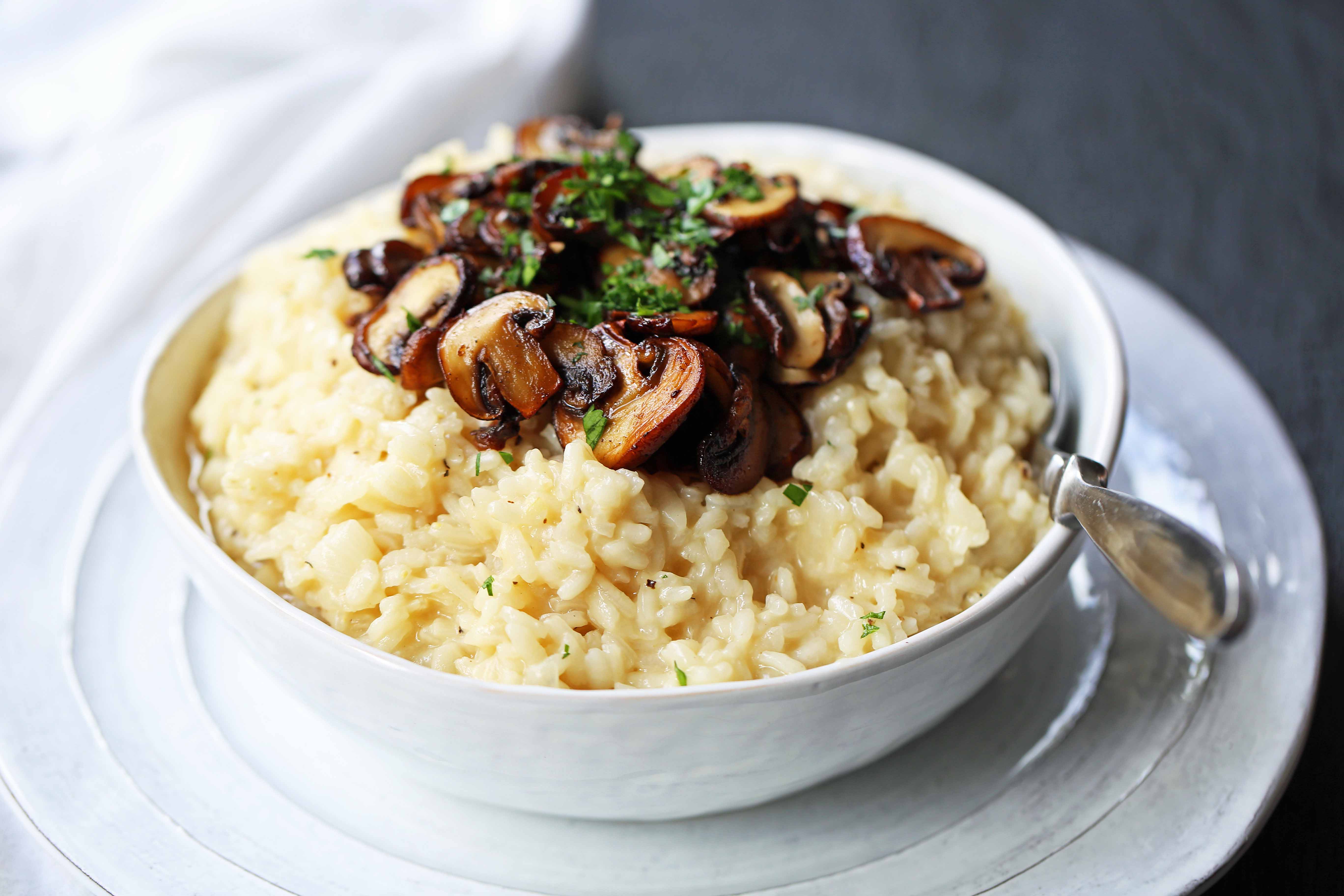 Creamy Mushroom Risotto. Rich, creamy rice slowly simmered with chicken broth, butter, parmesan cheese, and topped with butter sauteed mushrooms. www.modernhoney.com #risotto #homemaderisotto #mushroomrisotto