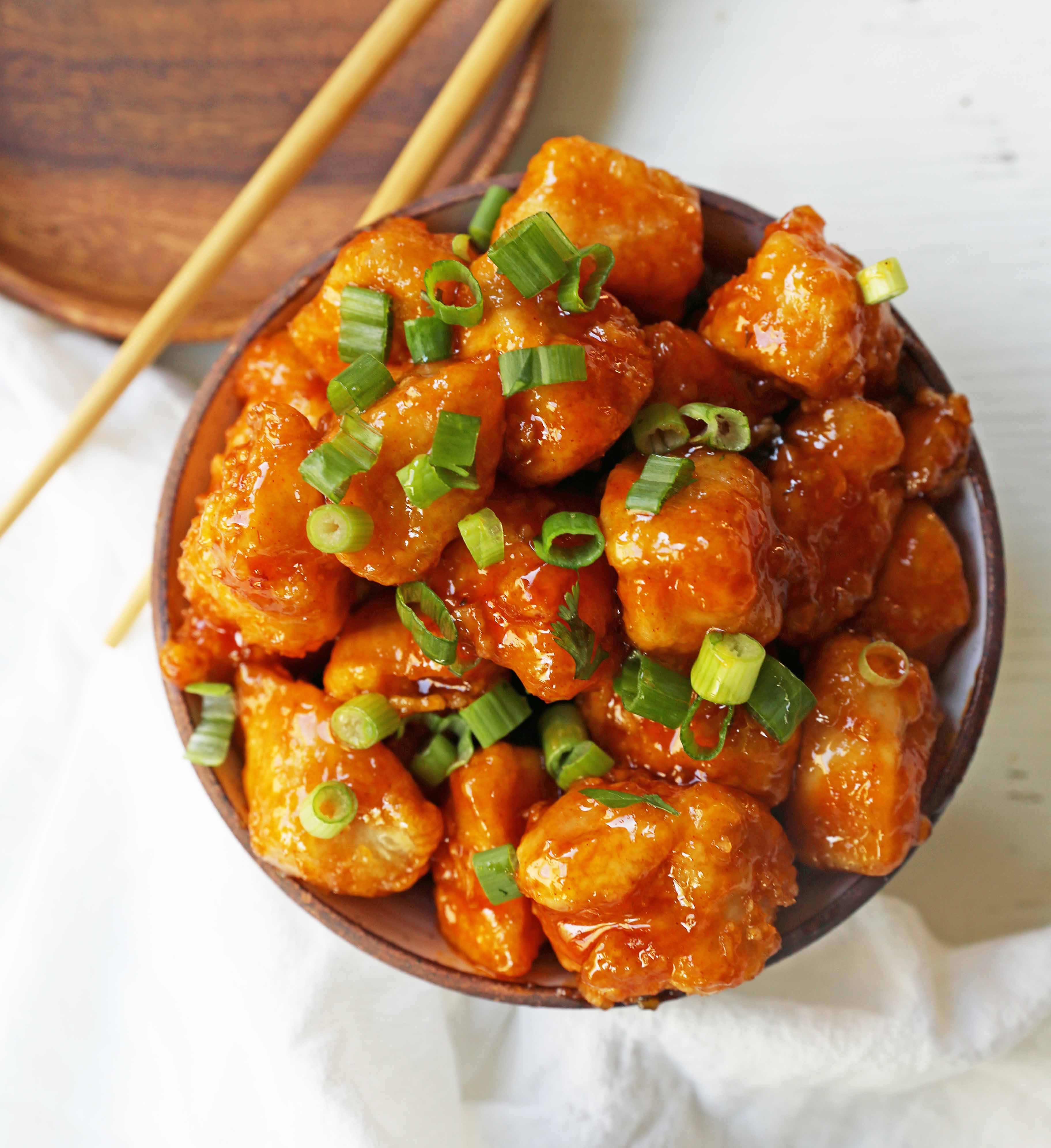 Firecracker Chicken. Sweet and spicy chicken bites made with tender chicken, flash-fried, and baked in a sweet brown sugar buffalo sauce. You'll have people coming back for seconds in no time at all! www.modernhoney.com #firecrackerchicken #buffalochicken #chicken #chickenbites 