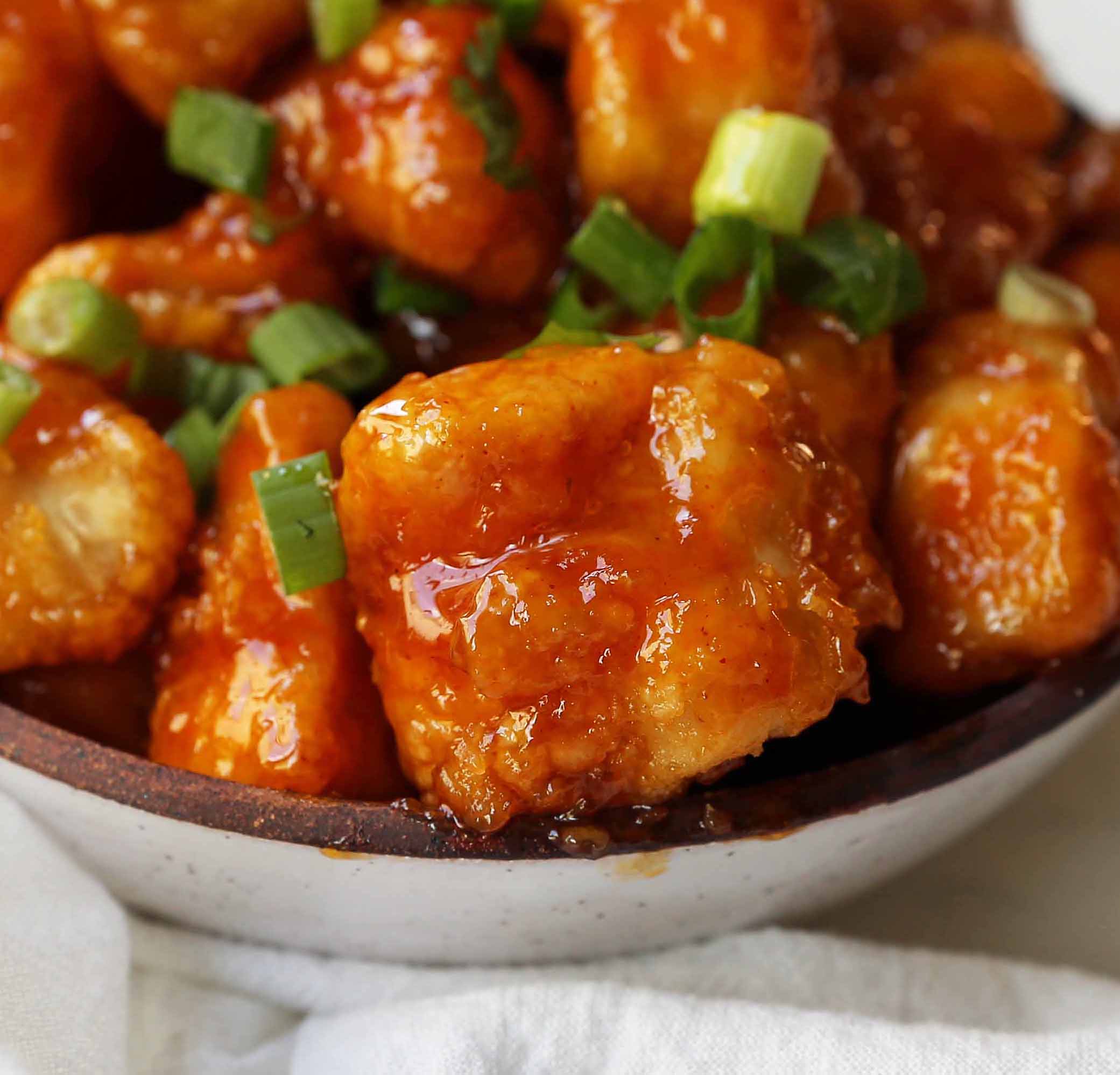 Firecracker Chicken. Sweet and spicy chicken bites made with tender chicken, flash-fried, and baked in a sweet brown sugar buffalo sauce. You'll have people coming back for seconds in no time at all! www.modernhoney.com #firecrackerchicken #buffalochicken #chicken #chickenbites 