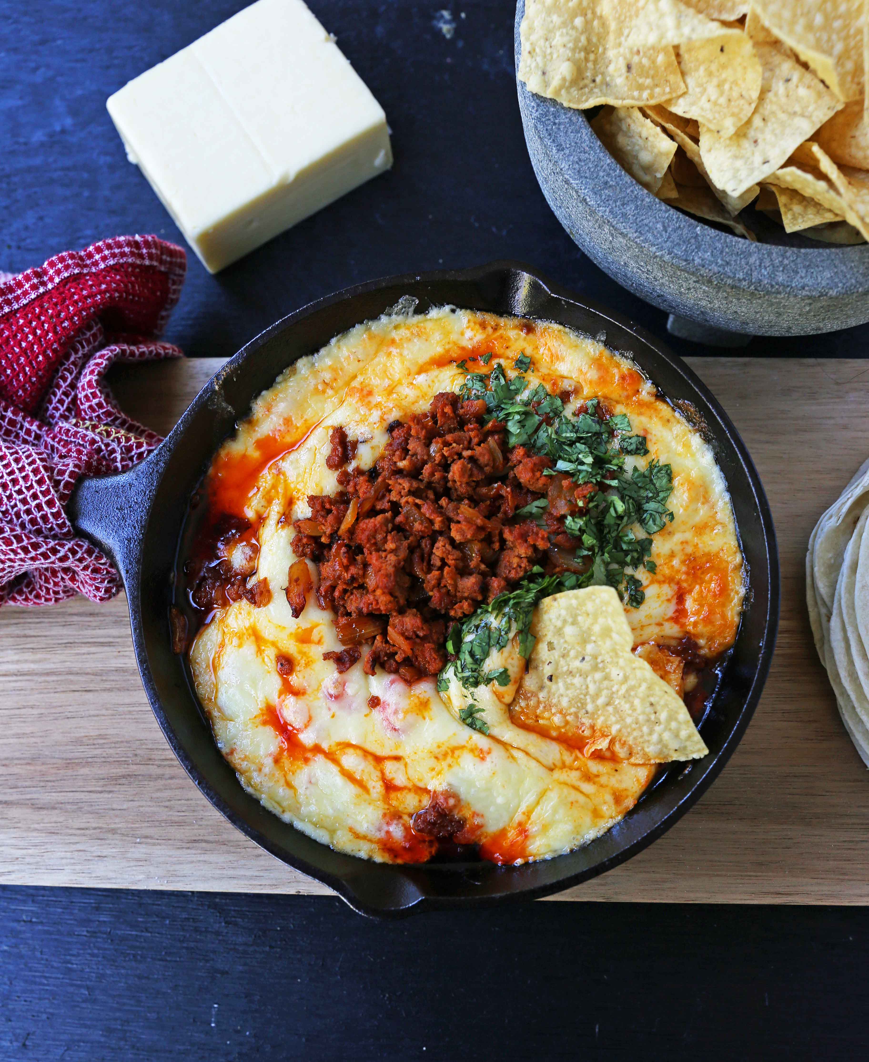Queso Fundido with Chorizo. A skillet of melted Mexican cheeses seasoned with peppers, onions, and spicy Mexican chorizo sausage and served with hot tortillas or chips. The perfect Mexican appetizer! www.modernhoney.com #appetizer #appetizers #mexican #mexicanfood #queso #quesofundido
