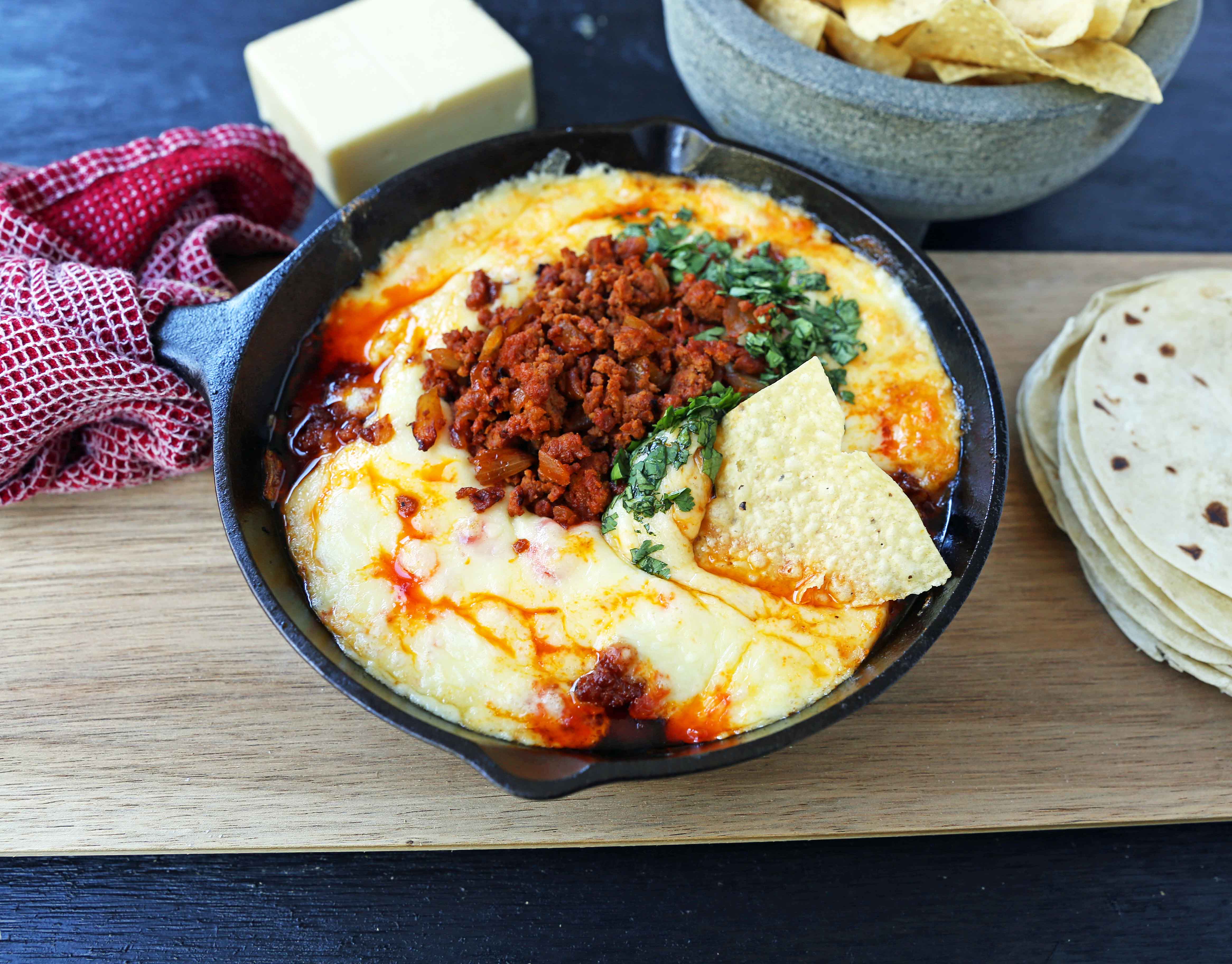 Queso Fundido with Chorizo. A skillet of melted Mexican cheeses seasoned with peppers, onions, and spicy Mexican chorizo sausage and served with hot tortillas or chips. The perfect Mexican appetizer! www.modernhoney.com #appetizer #appetizers #mexican #mexicanfood #queso #quesofundido