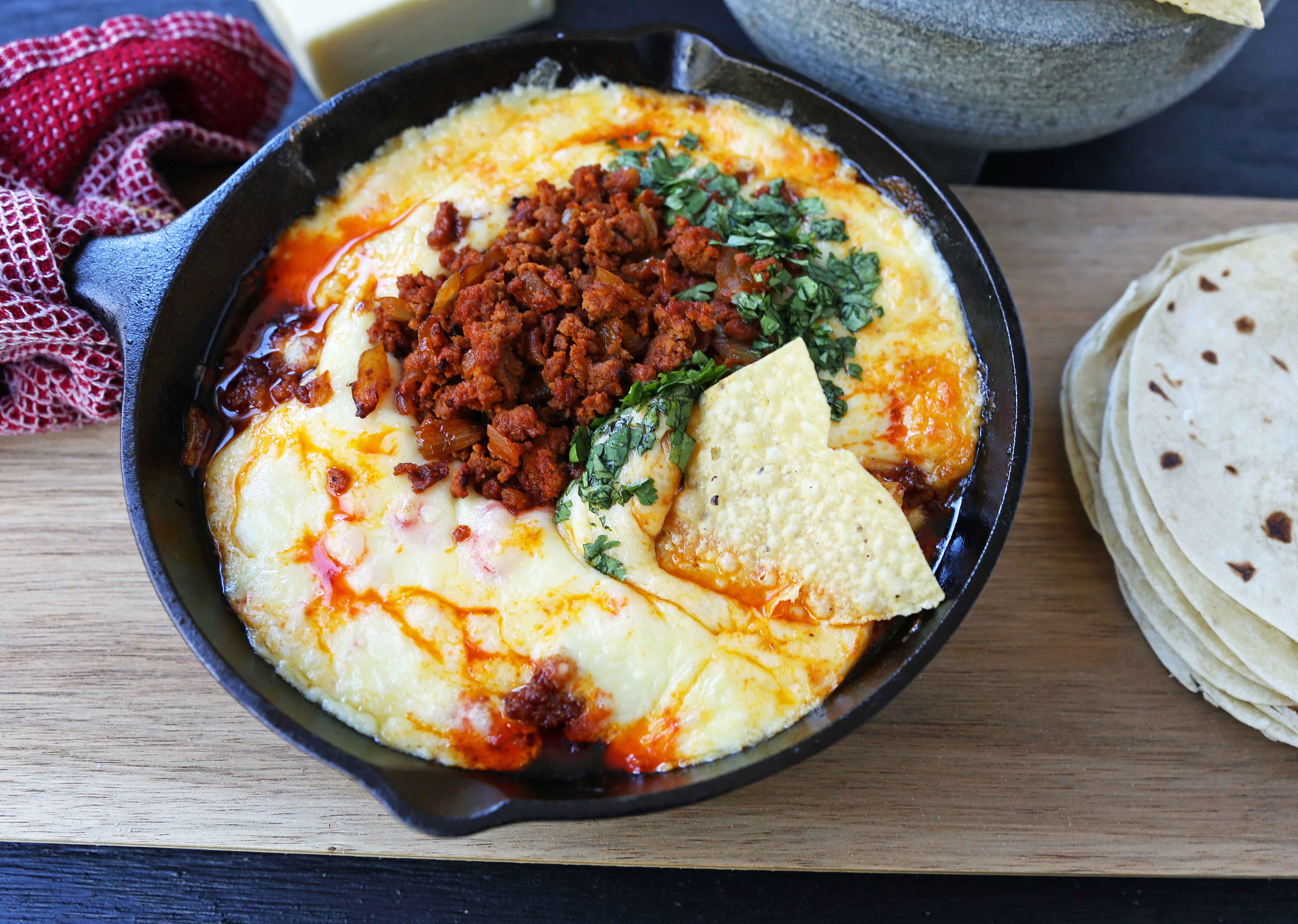 Queso Fundido with Chorizo. A skillet of melted Mexican cheeses seasoned with peppers, onions, and spicy Mexican chorizo sausage and served with hot tortillas or chips. The perfect Mexican appetizer! www.modernhoney.com #appetizer #appetizers #mexican #mexicanfood #queso #quesofundido