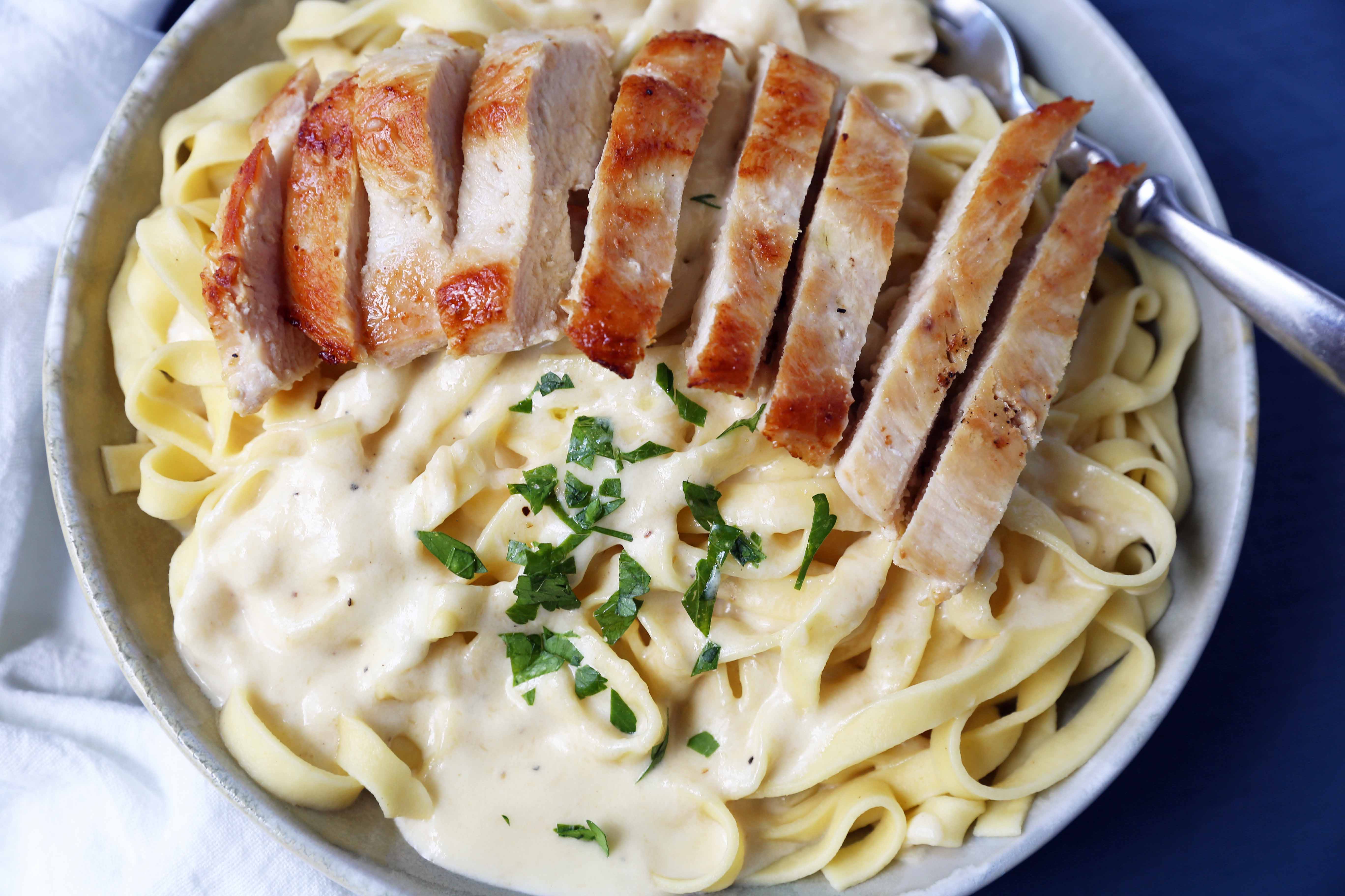 Chicken Fettucine Alfredo. Creamy parmesan cream sauce tossed with fettuccine pasta and topped with sauteed chicken. How to make the best chicken fettuccine alfredo. www.modernhoney.com #fettuccinealfredo #chickenfettuccinealfredo #pasta