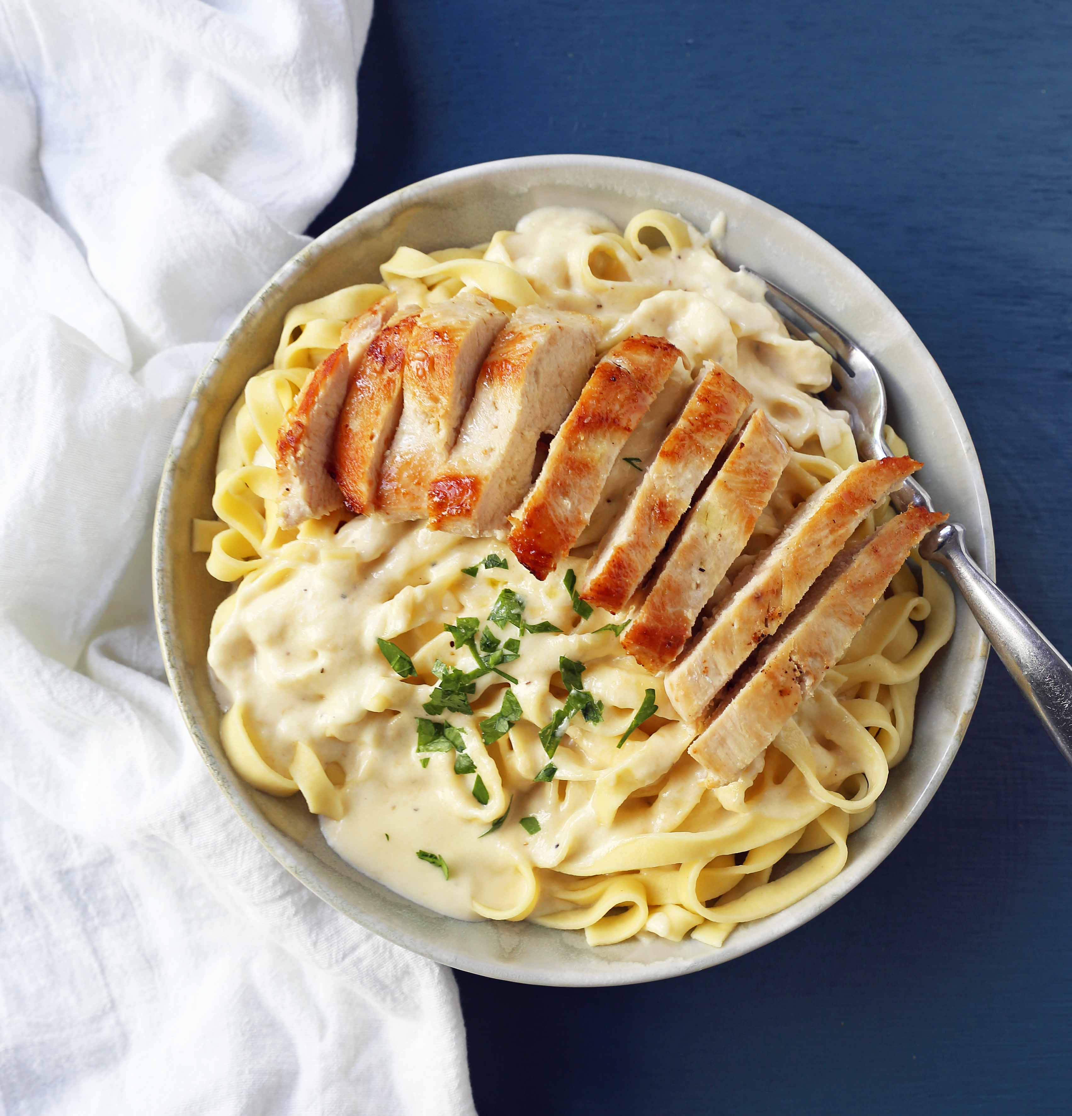 Chicken Fettucine Alfredo. Creamy parmesan cream sauce tossed with fettuccine pasta and topped with sauteed chicken. How to make the best chicken fettuccine alfredo. www.modernhoney.com #fettuccinealfredo #chickenfettuccinealfredo #pasta