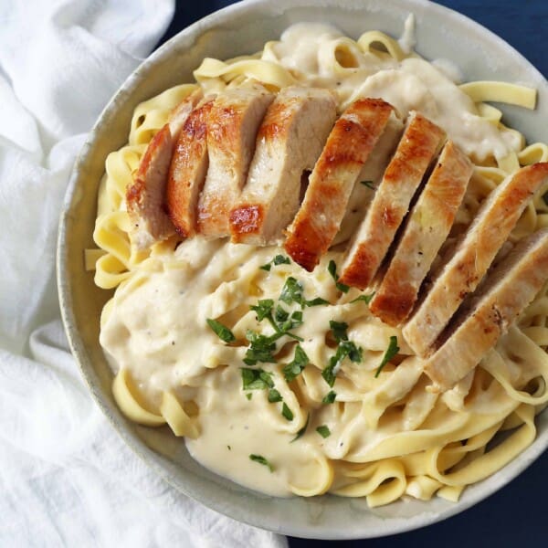 Chicken Fettucine Alfredo. Creamy parmesan cream sauce tossed with fettuccine pasta and topped with sauteed chicken. How to make the best chicken fettuccine alfredo. www.modernhoney.com #fettuccinealfredo #chickenfettuccinealfredo #pasta